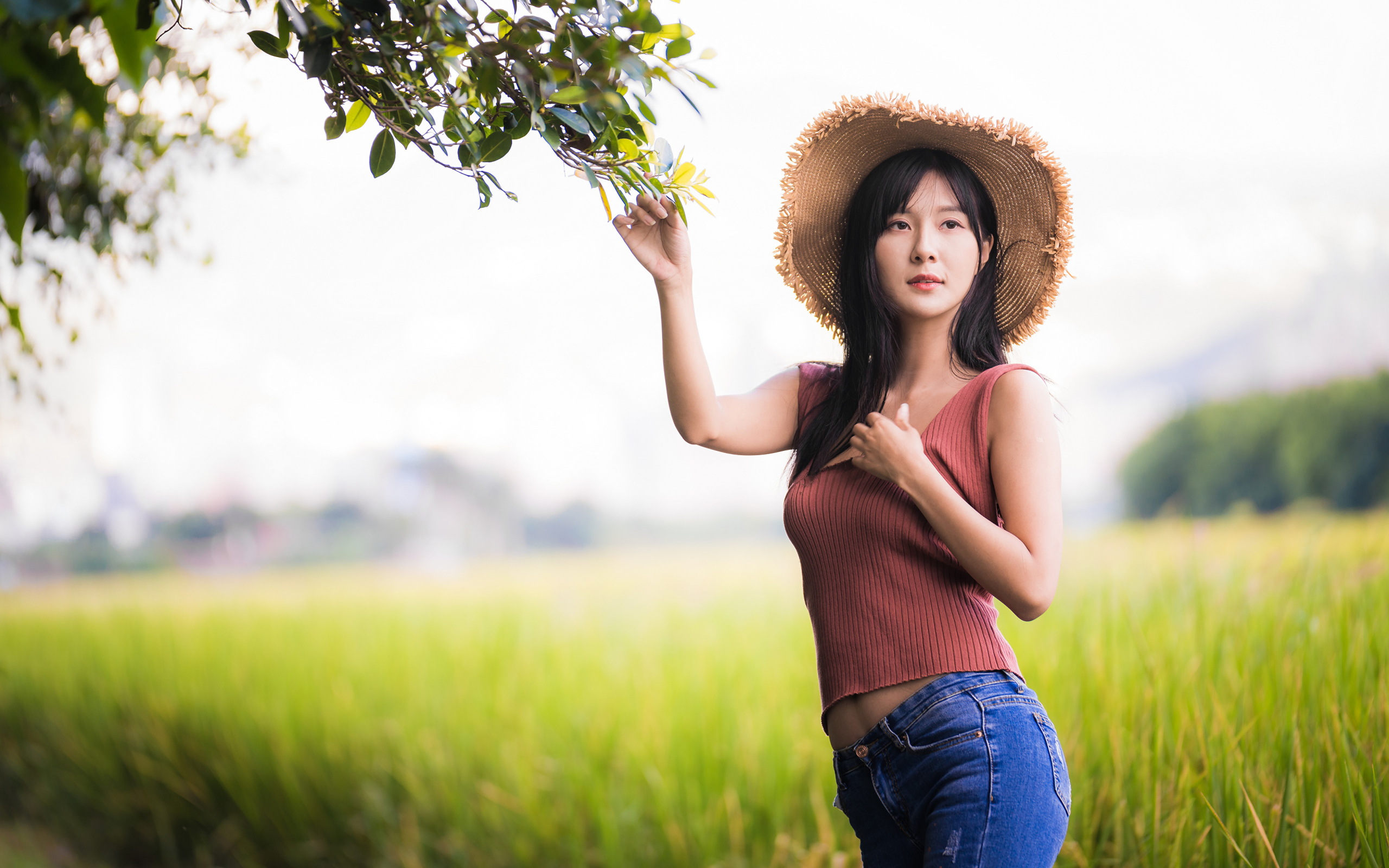 Девушка азиатка в шляпе на поле 