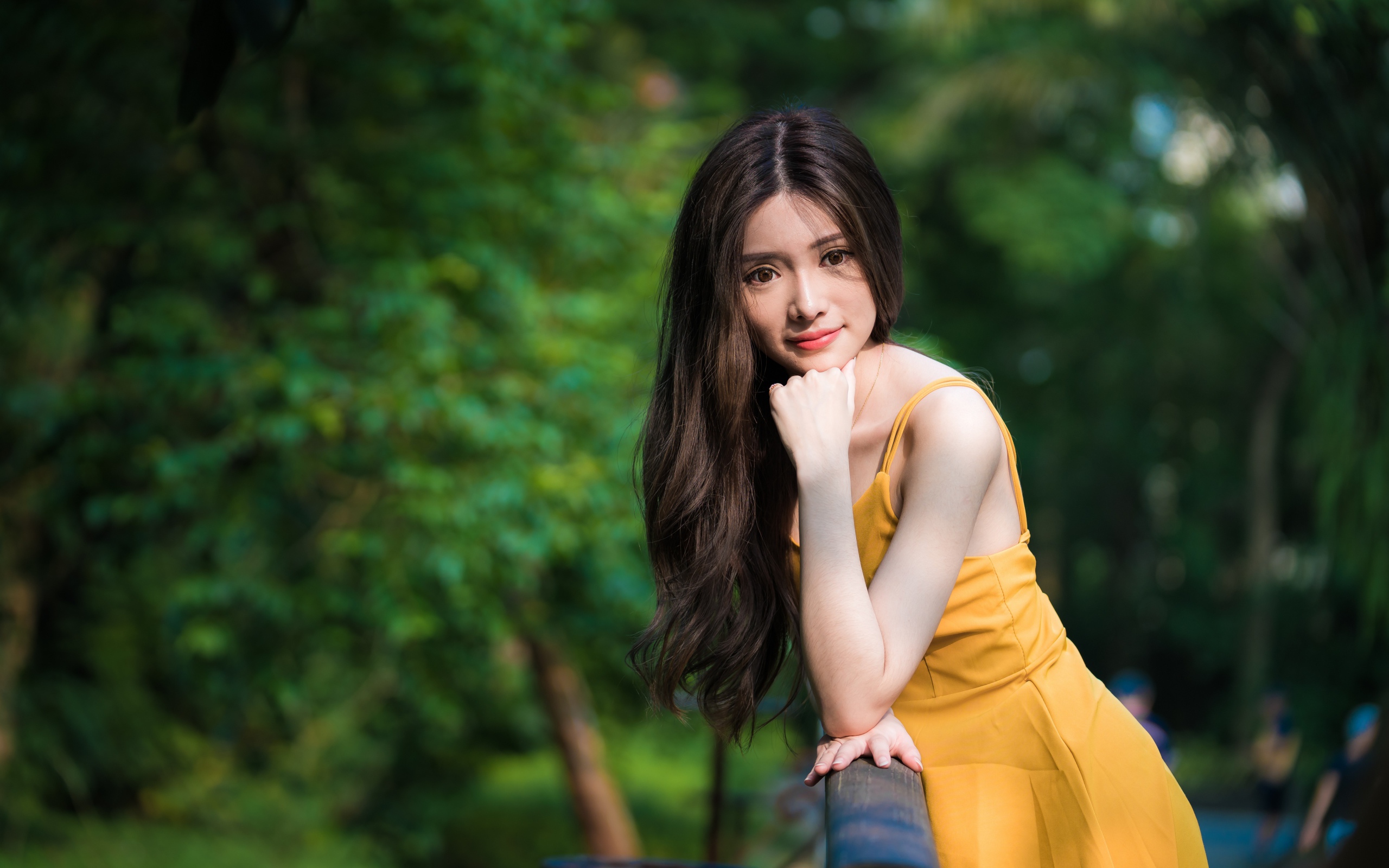 Девушка азиатка с большими карими глазами в желтом платье 