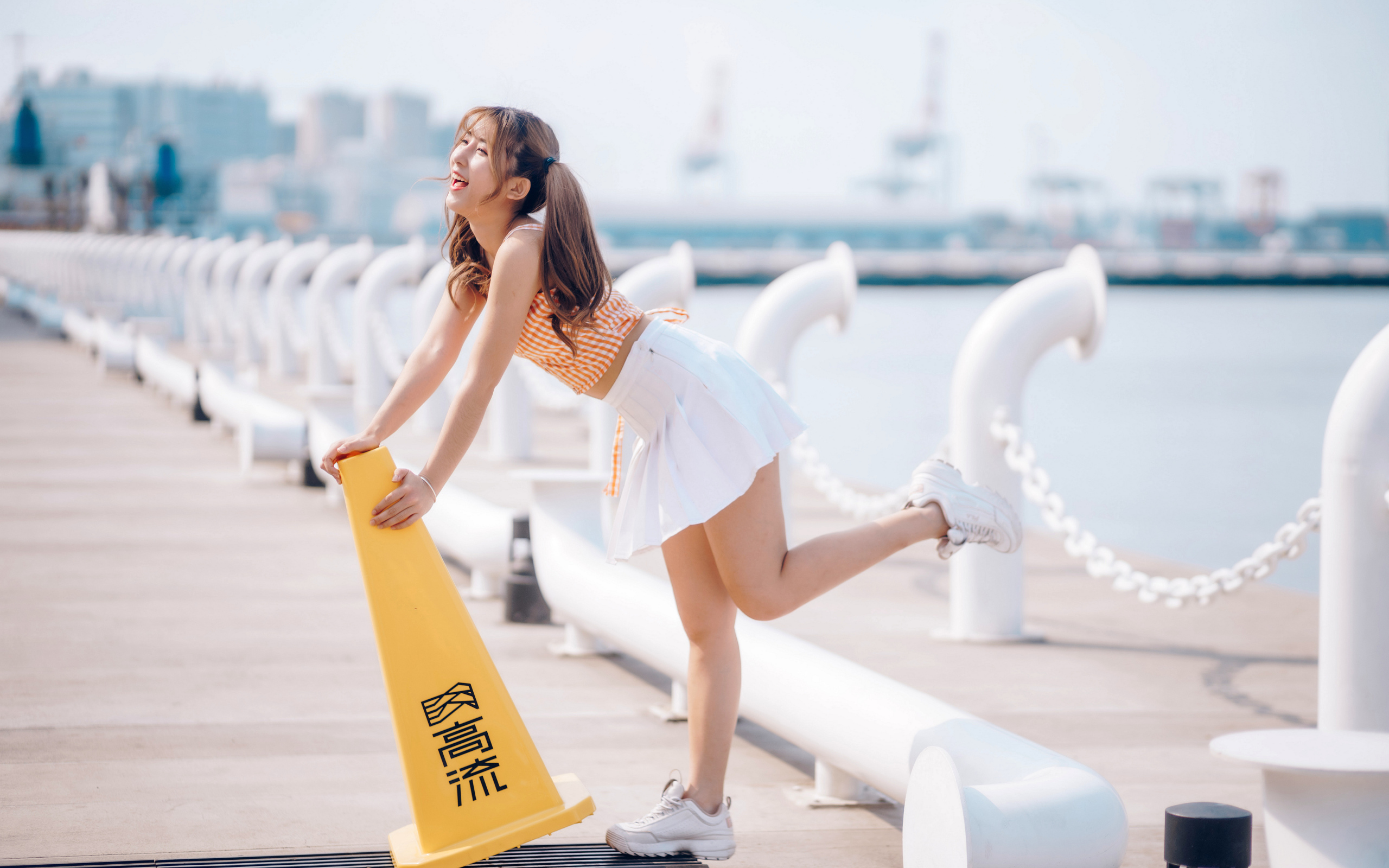 Азиатка с короткой белой юбке у воды 