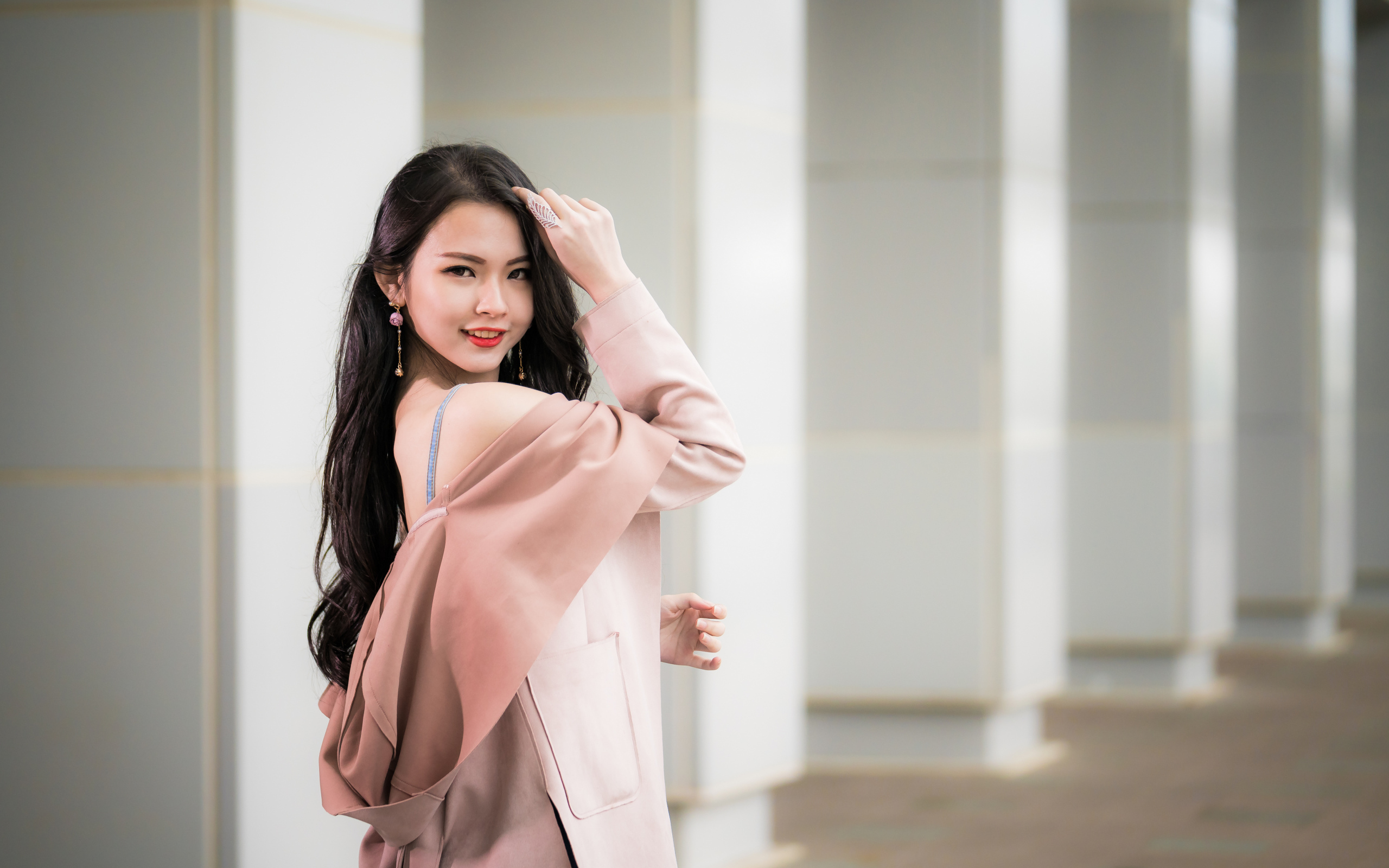 Красивая девушка азиатка с длинными волосами в розовом пальто 