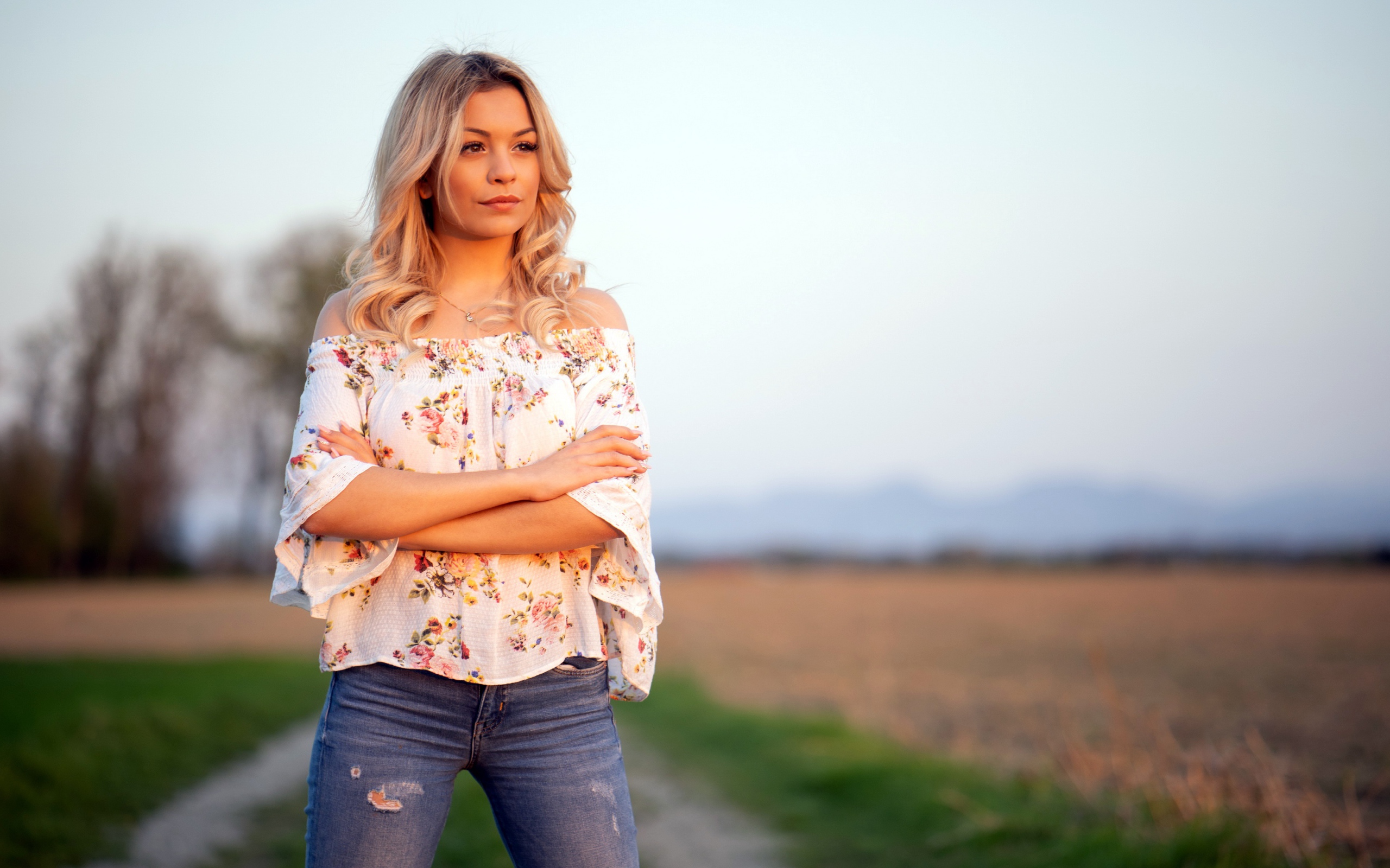 Красивая девушка блондинка в джинсах в поле