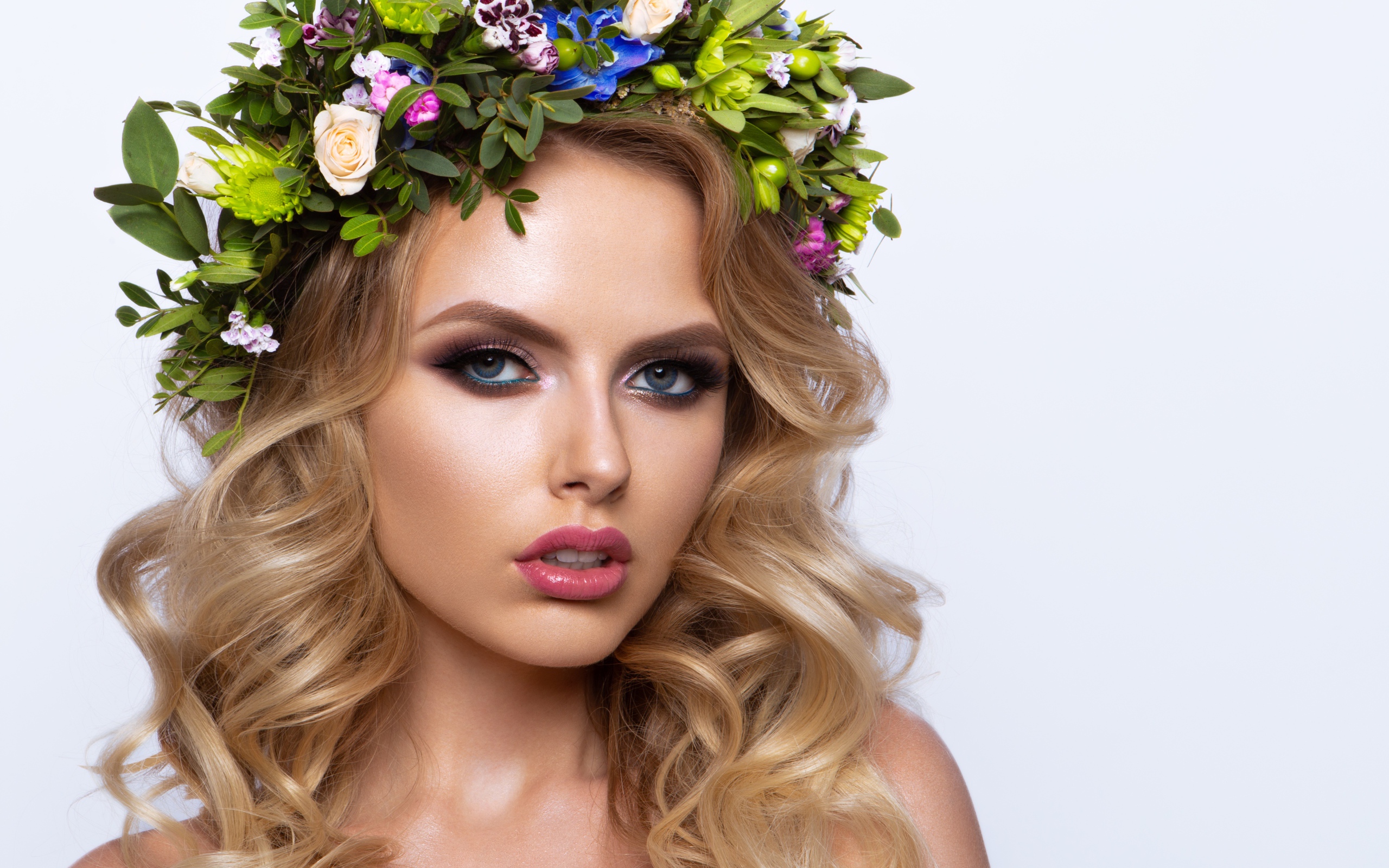 Красивая блондинка с венком из живых цветов на белом фоне