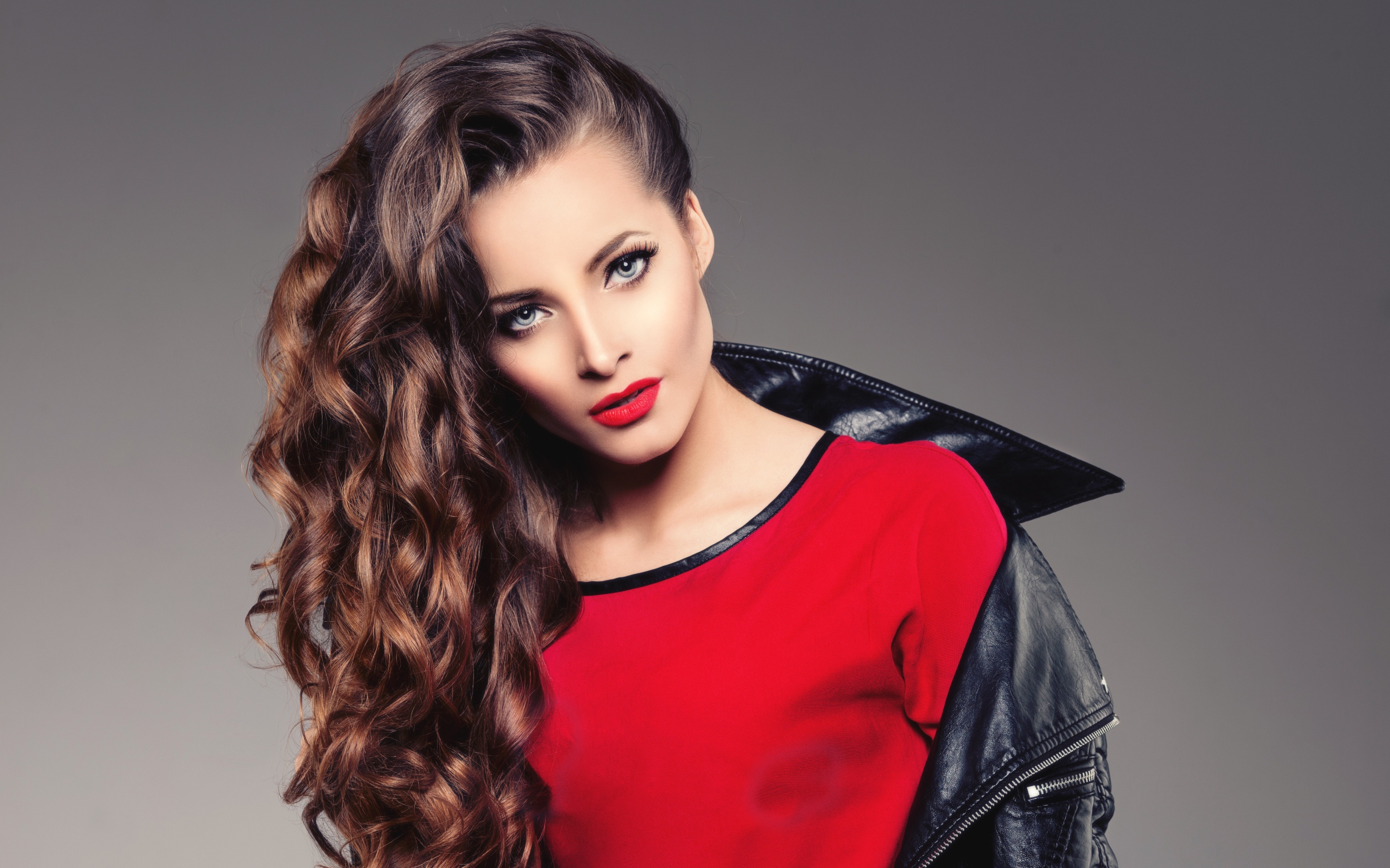 Красивая девушка в черной кожаной куртке и красном свитере