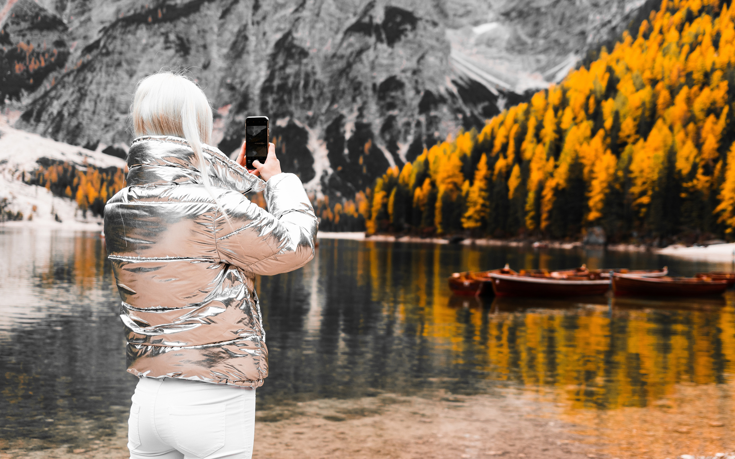 Красивая девушка делает фото гор на телефон 