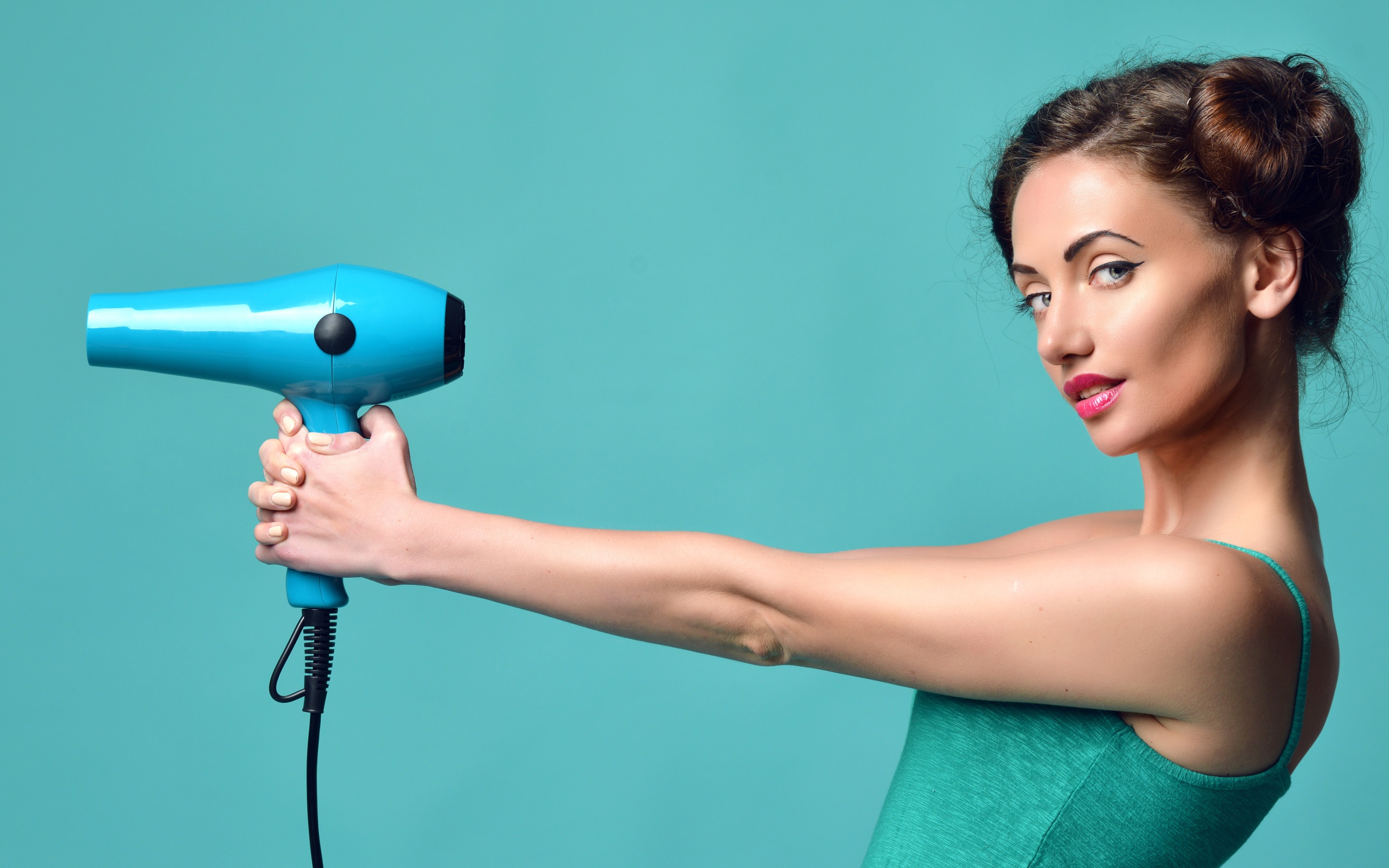 Beautiful girl with a hairdryer in hands on a blue background