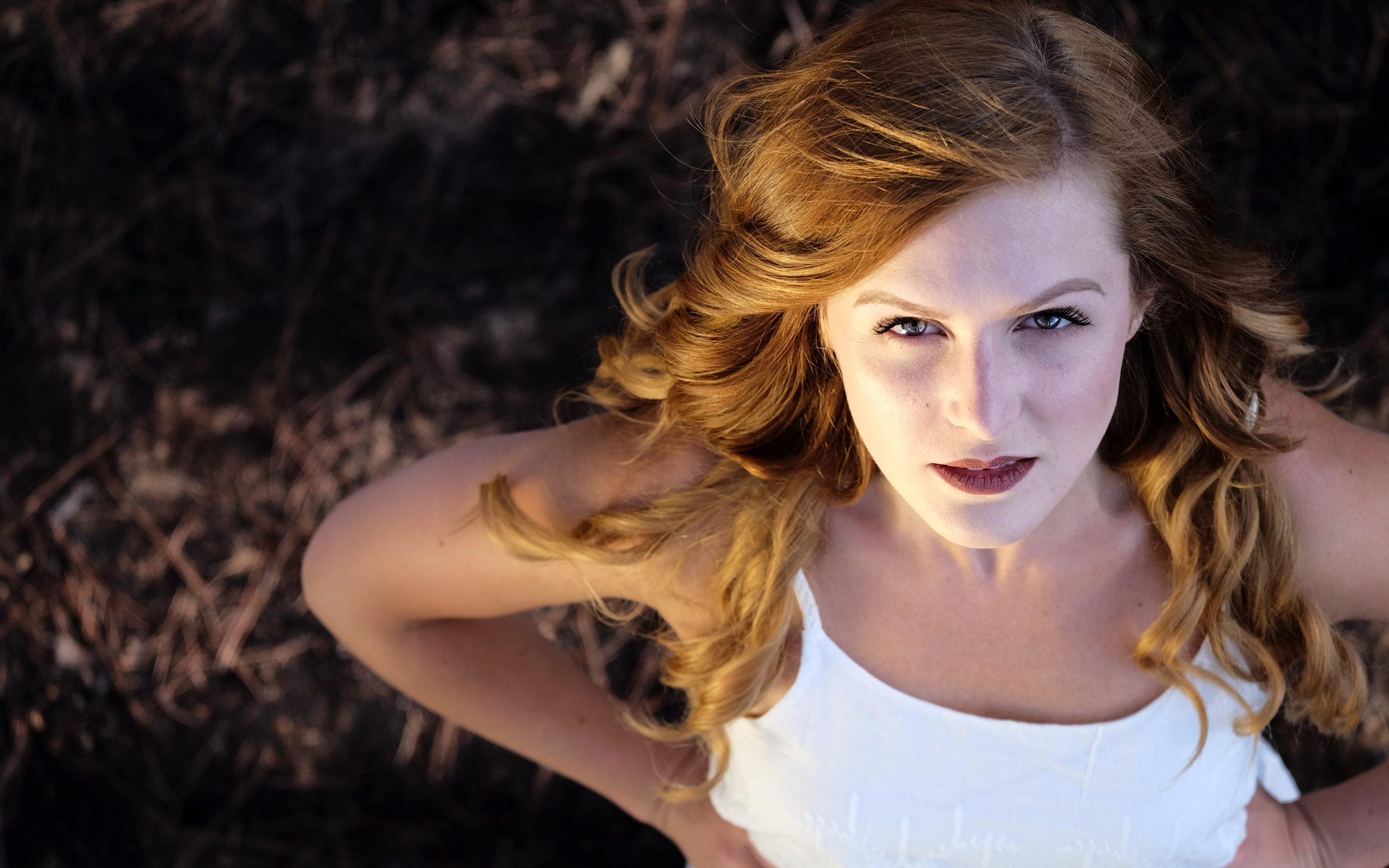 Красивый взгляд рыжеволосой девушки в белом платье