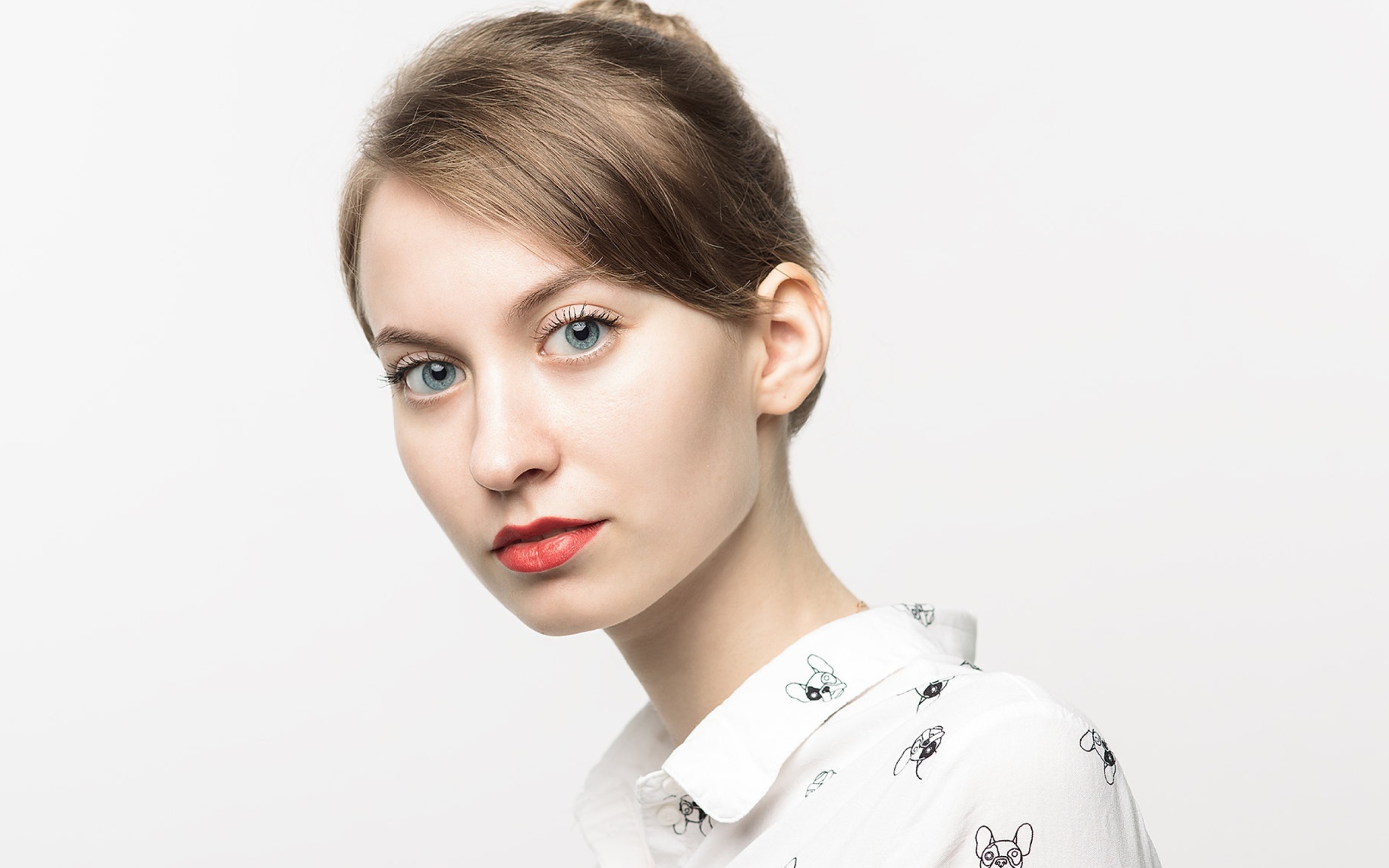 Милая голубоглазая девушка в рубашке на сером фоне