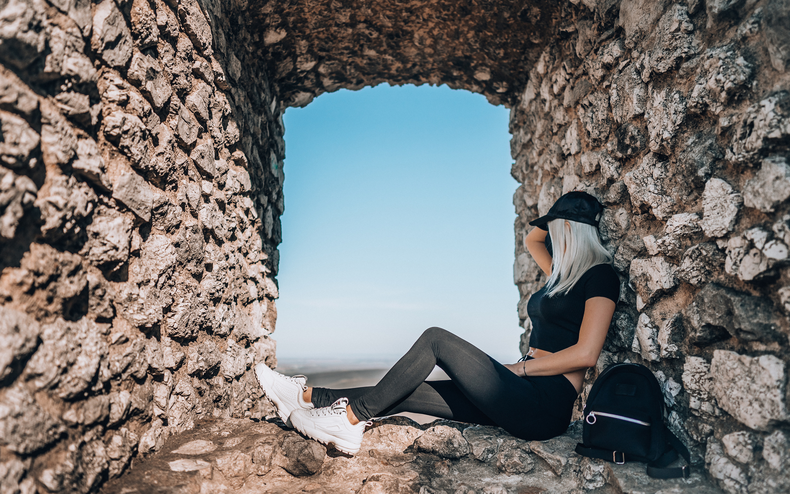 Девушка сидит в окне старого здания 