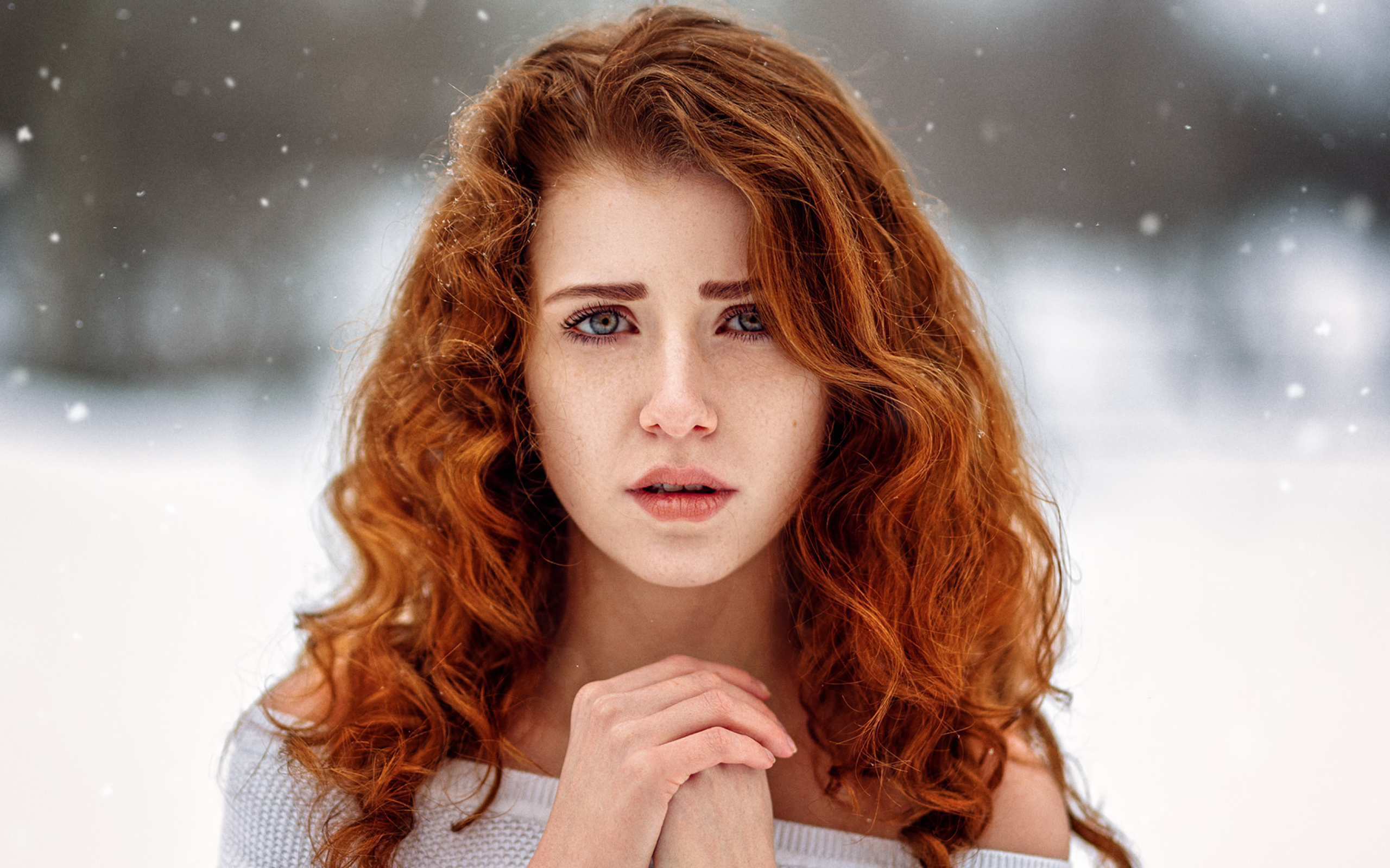 Рыжеволосая девушка замерзает на улице зимой