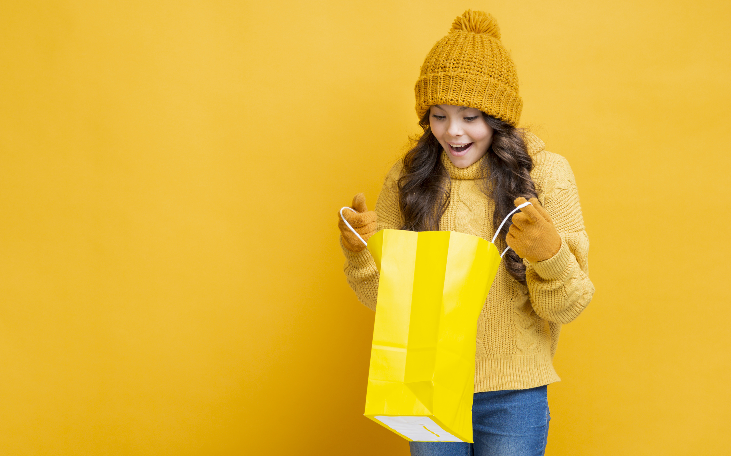 Улыбающаяся девушка в теплом свитере  с пакетом в руках 
