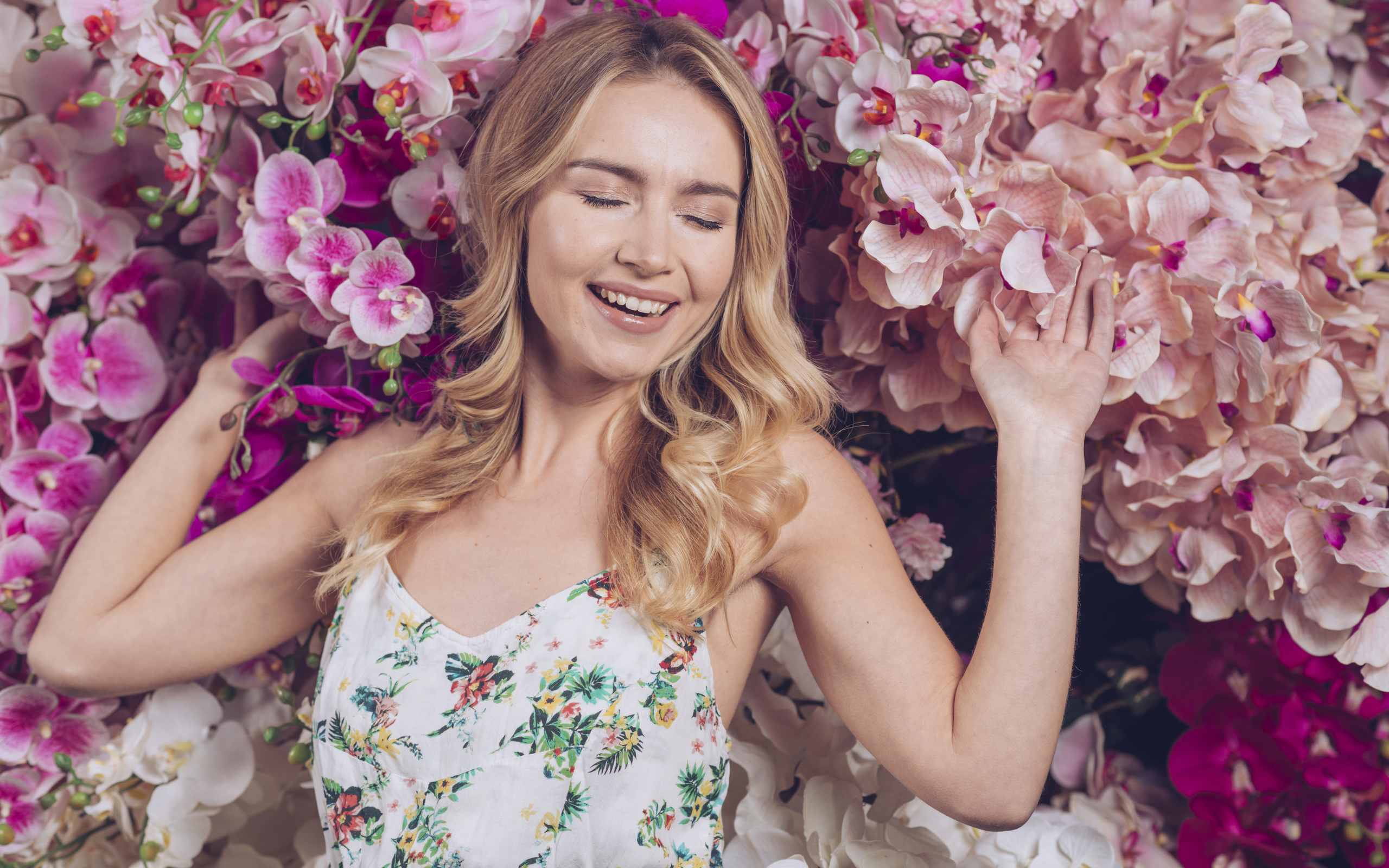 Улыбающаяся счастливая девушка у цветов орхидеи