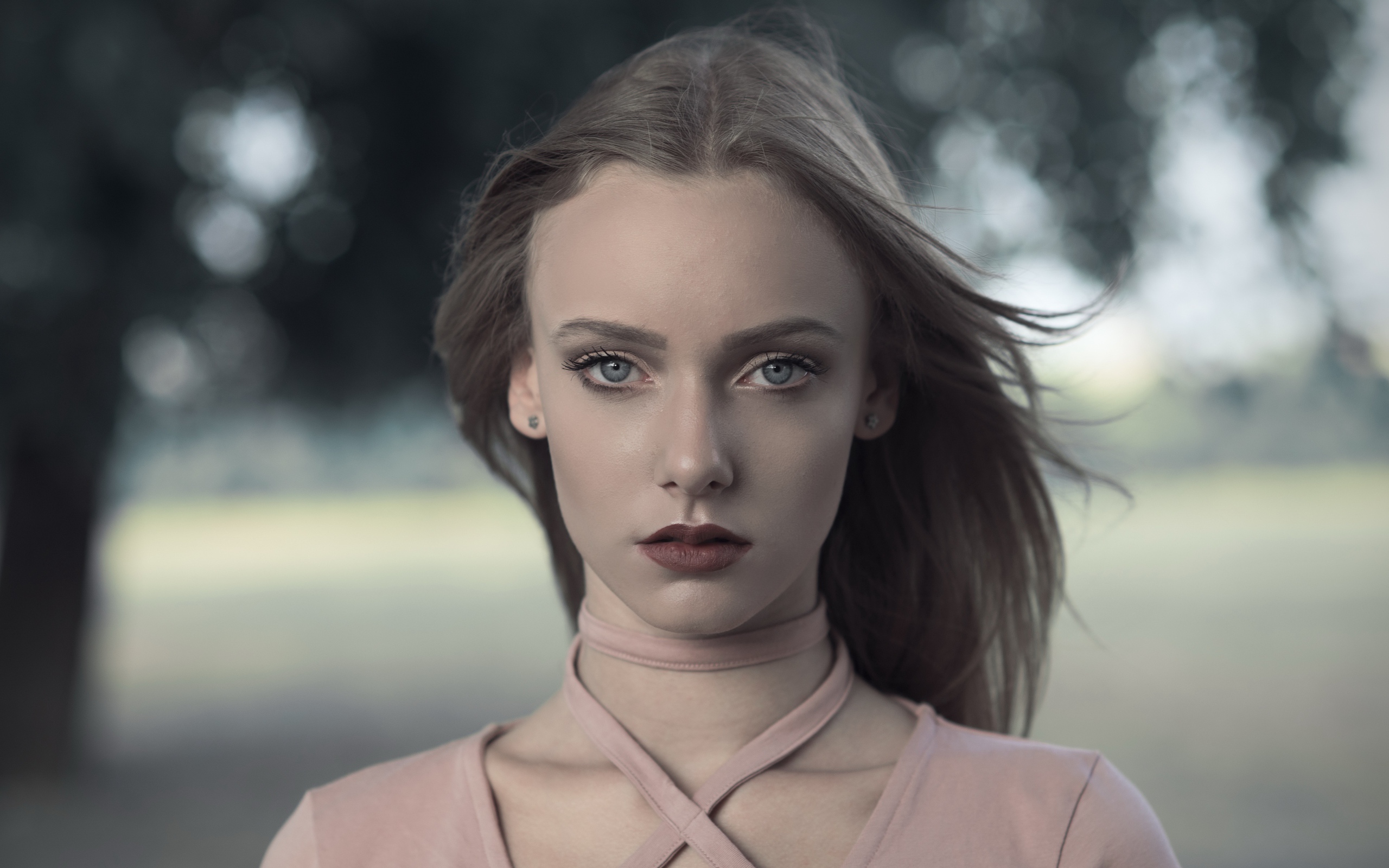 Ветер развивает волосы красивой голубоглазой девушки