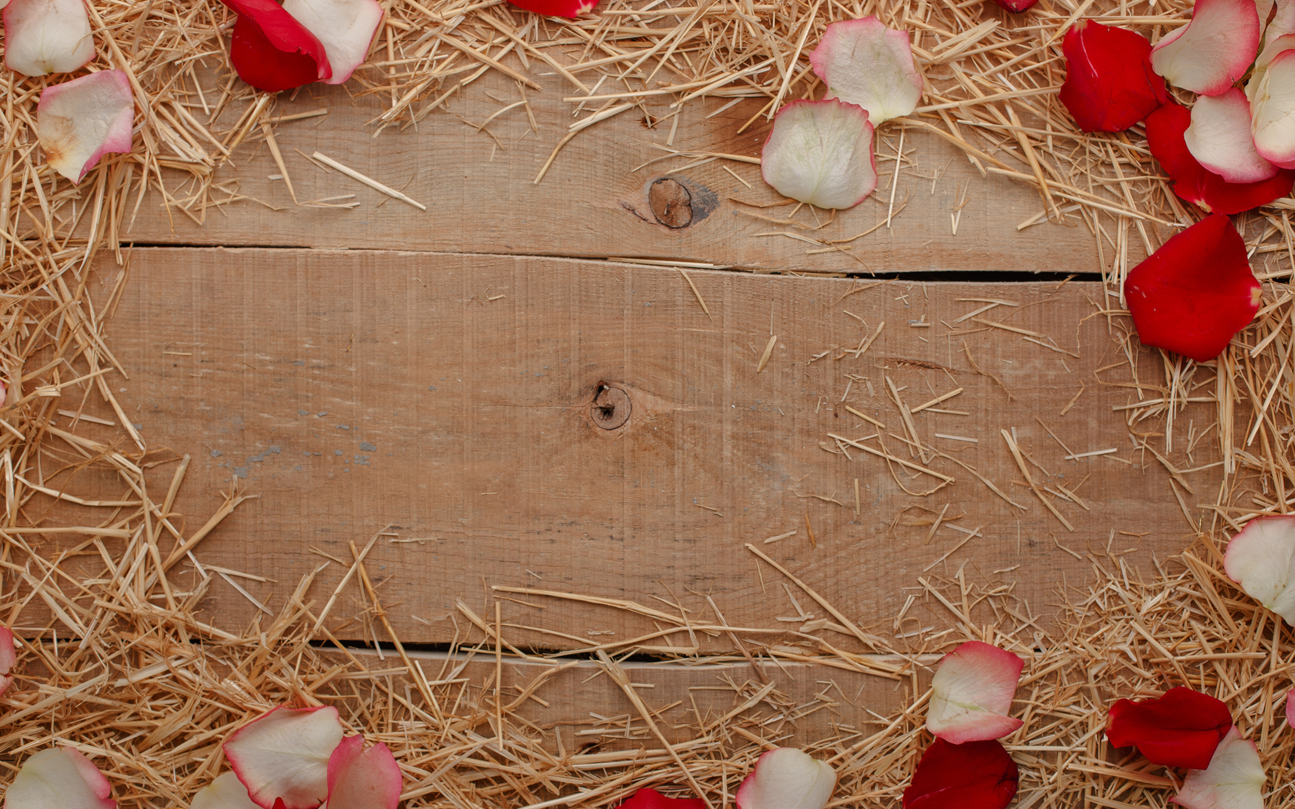 Сено и лепестки роз на деревянном столе 
