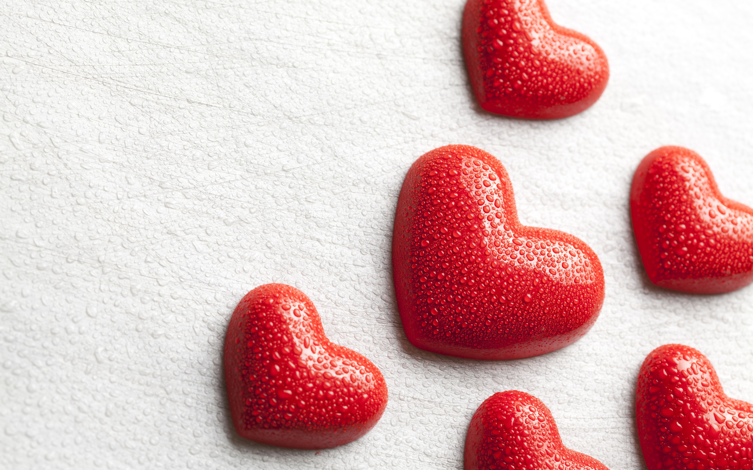 Мокрые красные сердечки на белом фоне