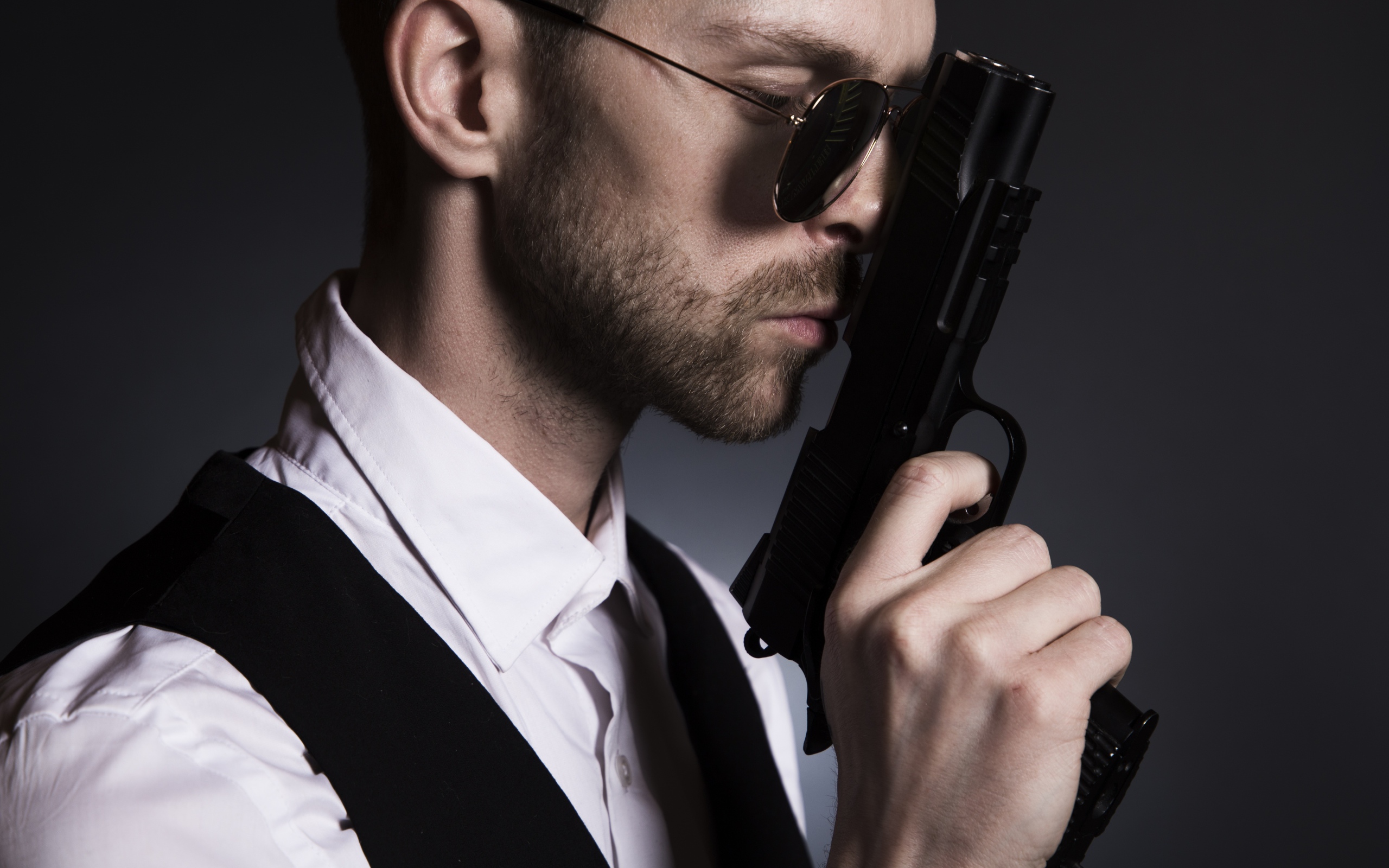 Мужчина в очках с пистолетом в руке