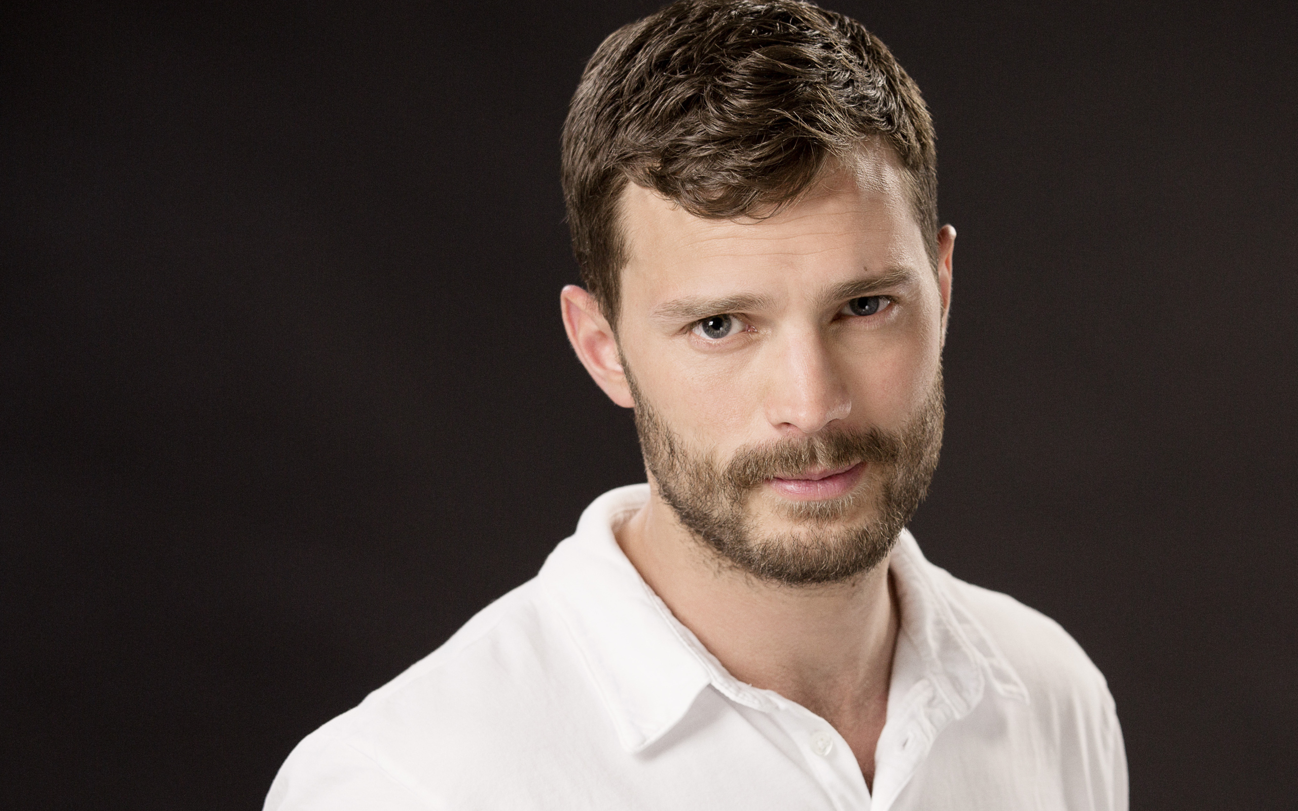 Красивый мужчина, актер Джеми Дорнан в белой рубашке