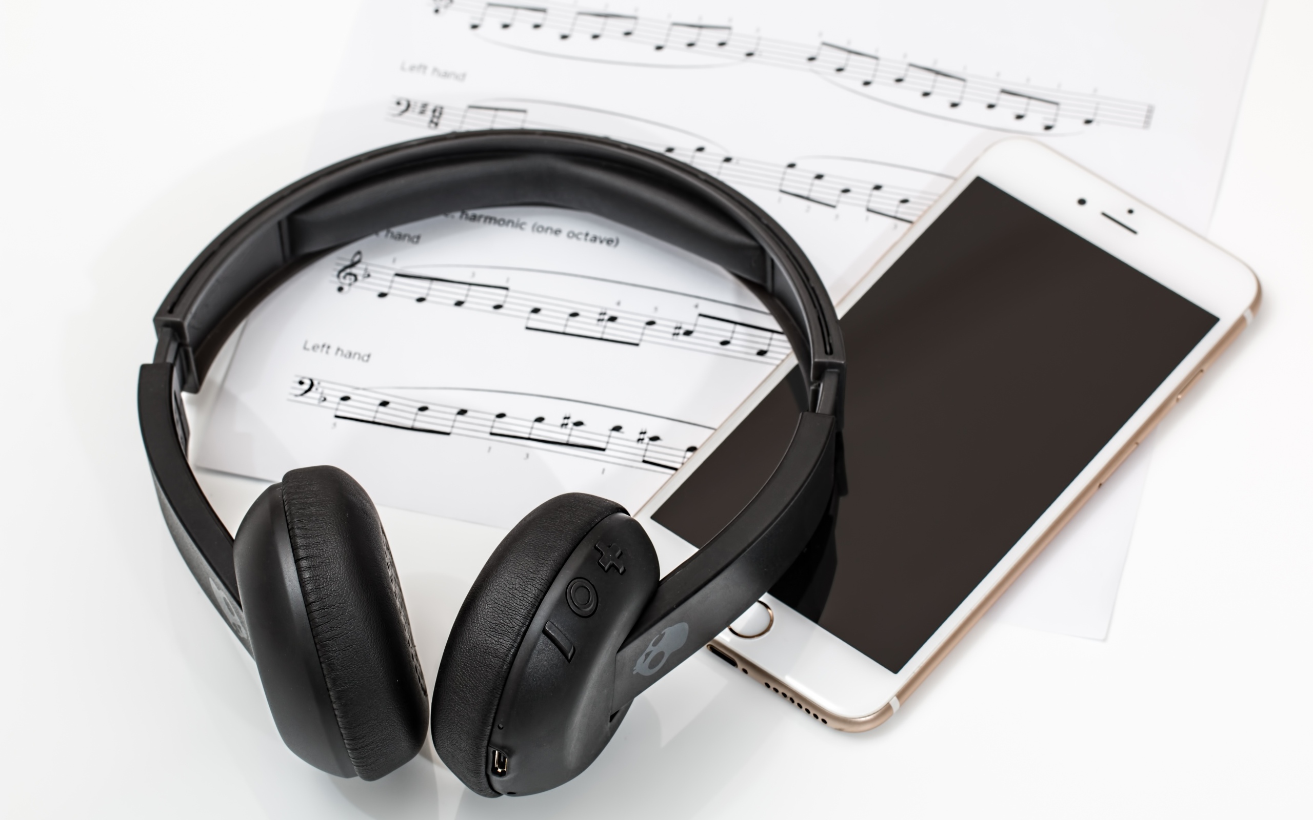 Наушники на столе с нотами и смартфоном