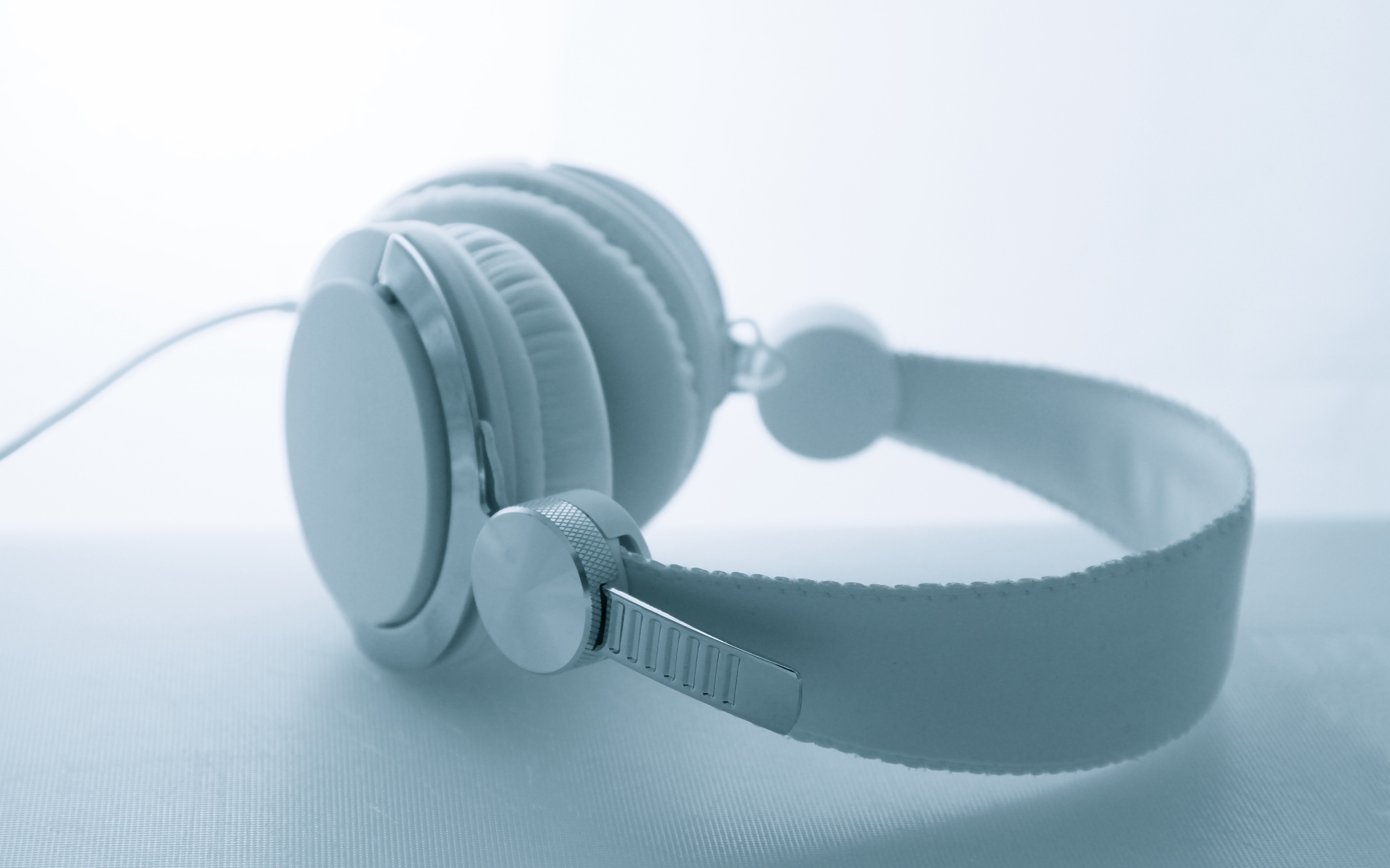 Белые большие наушники лежат на белом фоне