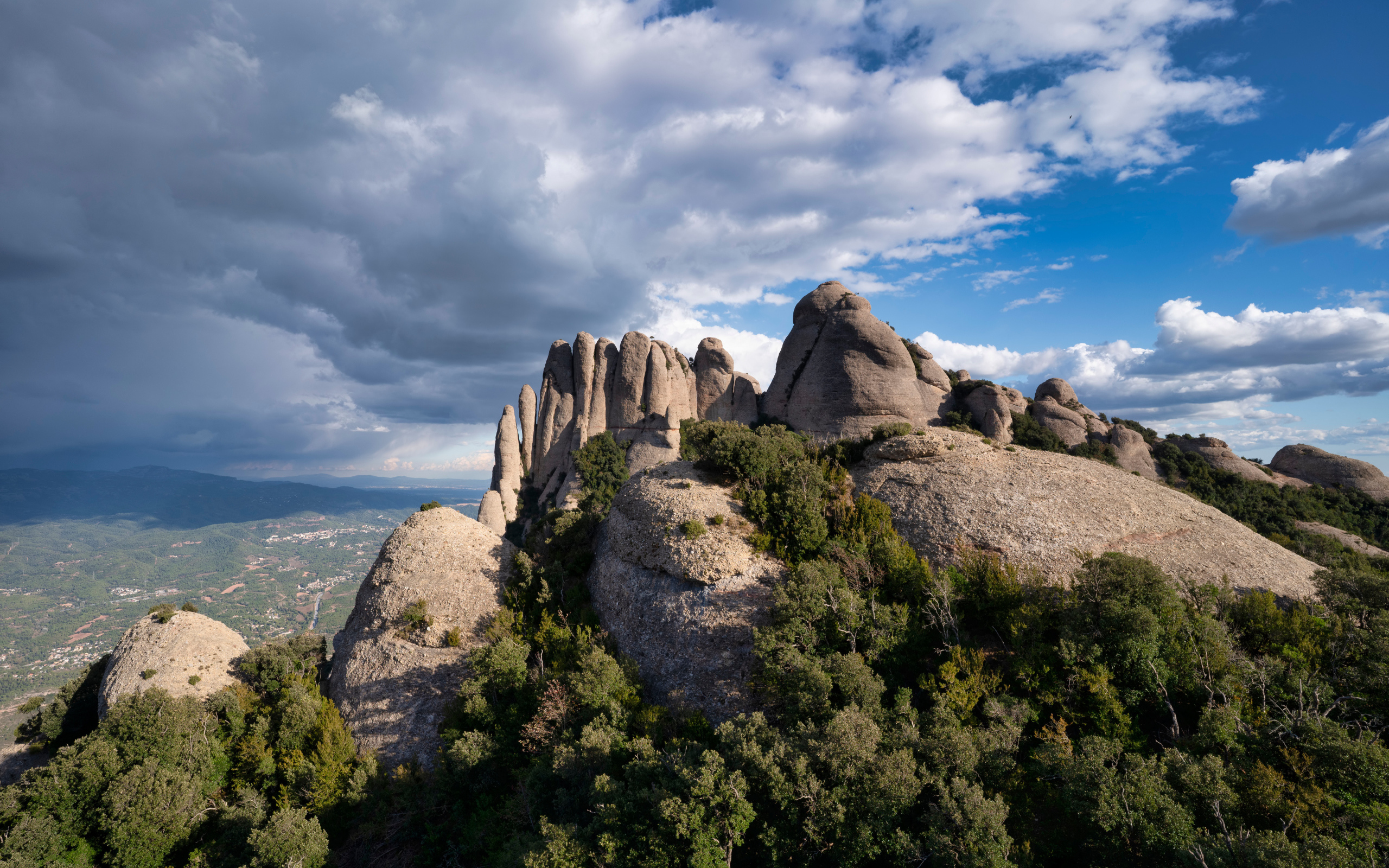 Каменные глыбы под голубым небом с грозовыми облаками 