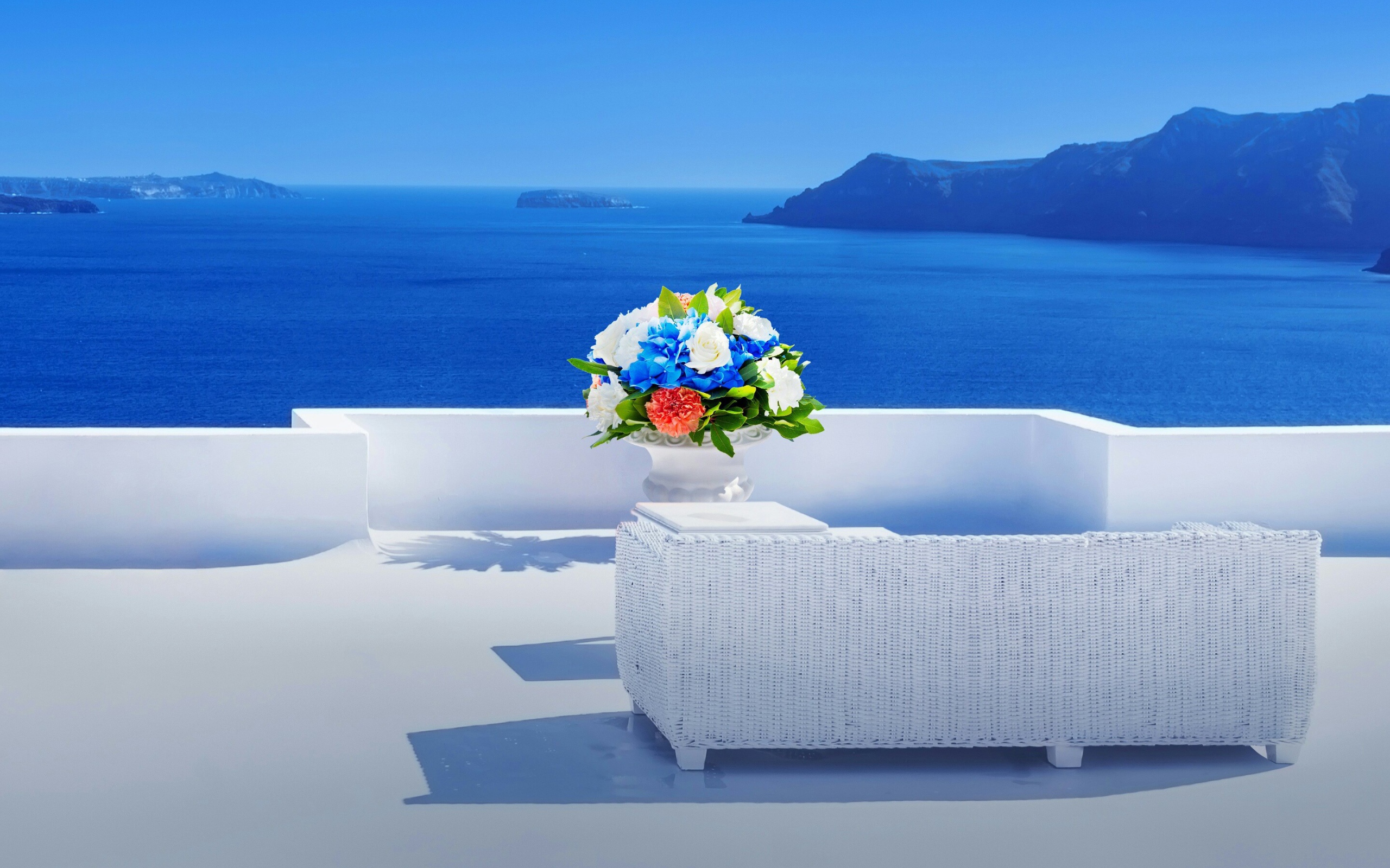 Красивый букет цветов на белом столе на фоне моря