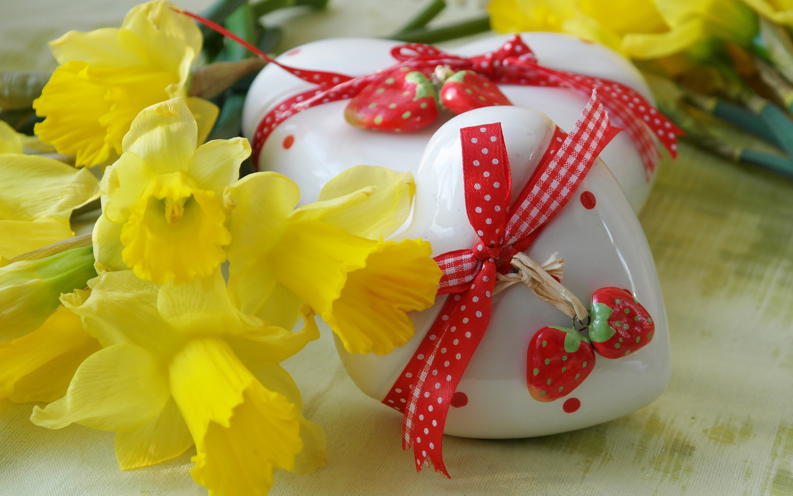Два белых фарфоровых сердца с букетом желтых нарциссов