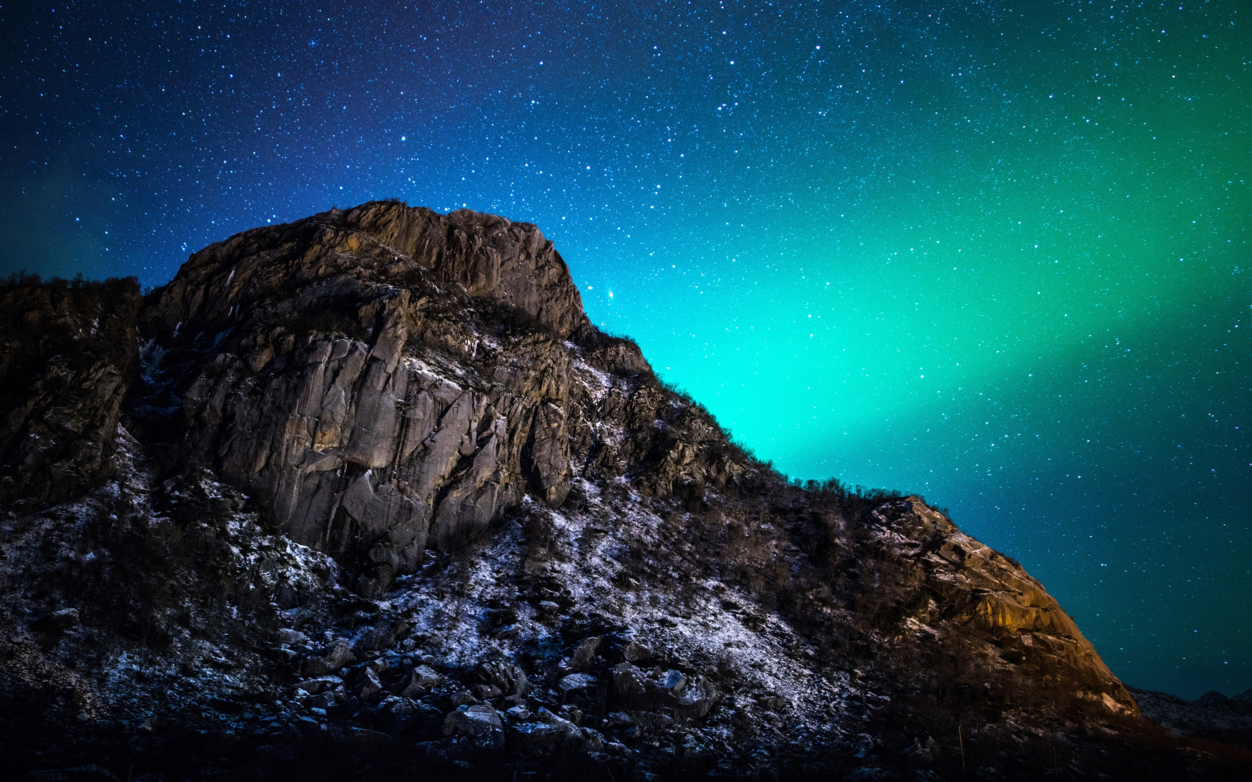 Красивое зеленое полярное сияние в звездном небе над горой 