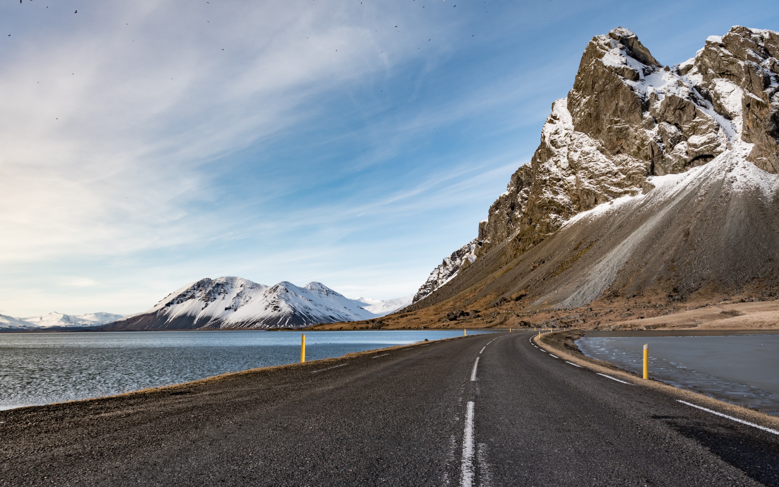 Асфальтовая дорога ведет в горы под голубым небом