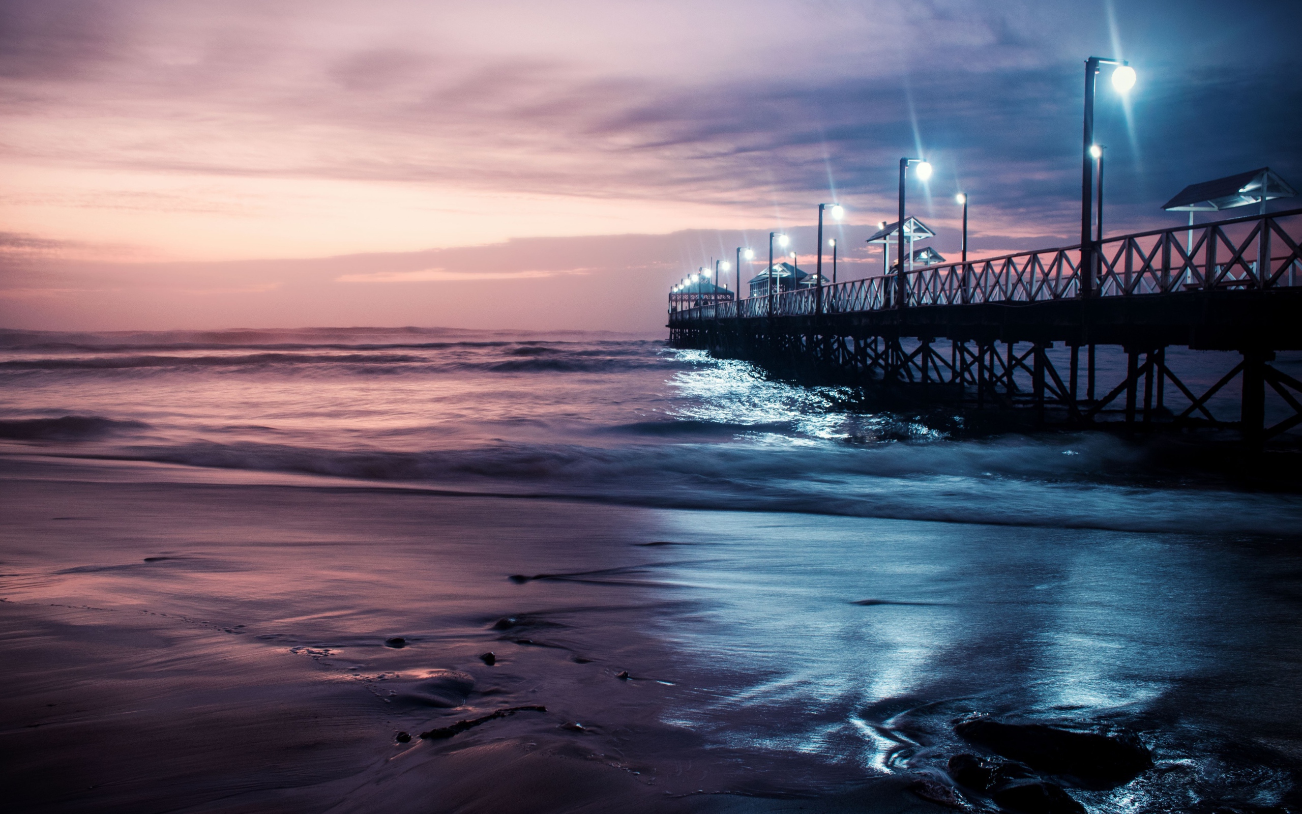 Вид на мост в океане с включенными фонарями ночью