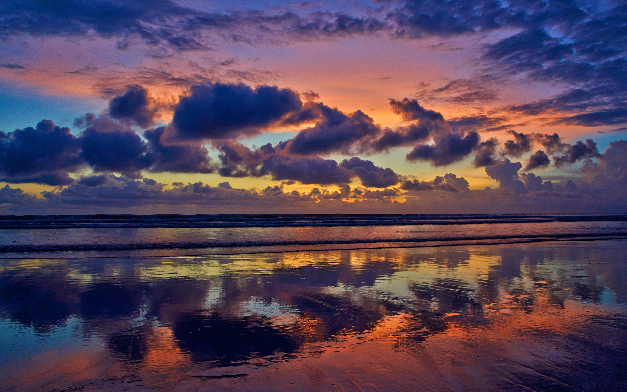 Черные тучи отражаются в морской воде на закате
