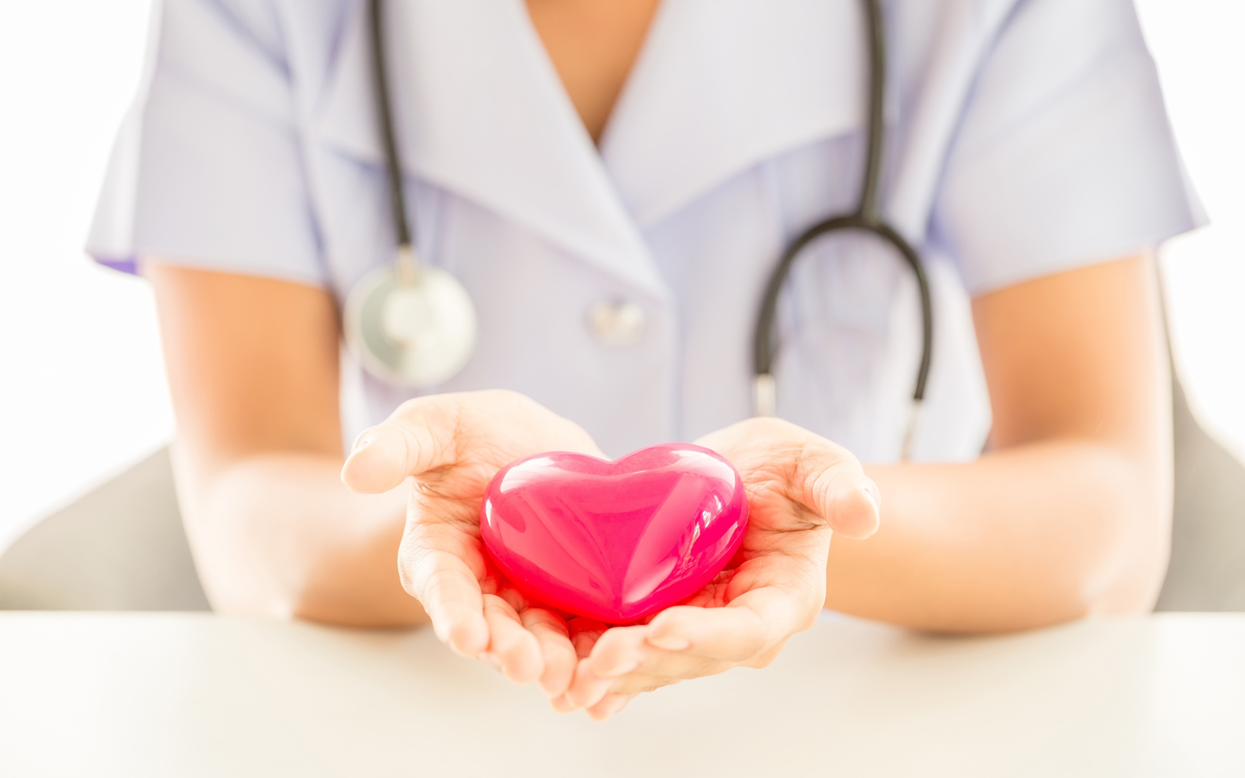 Стеклянное сердце в руках у врача 