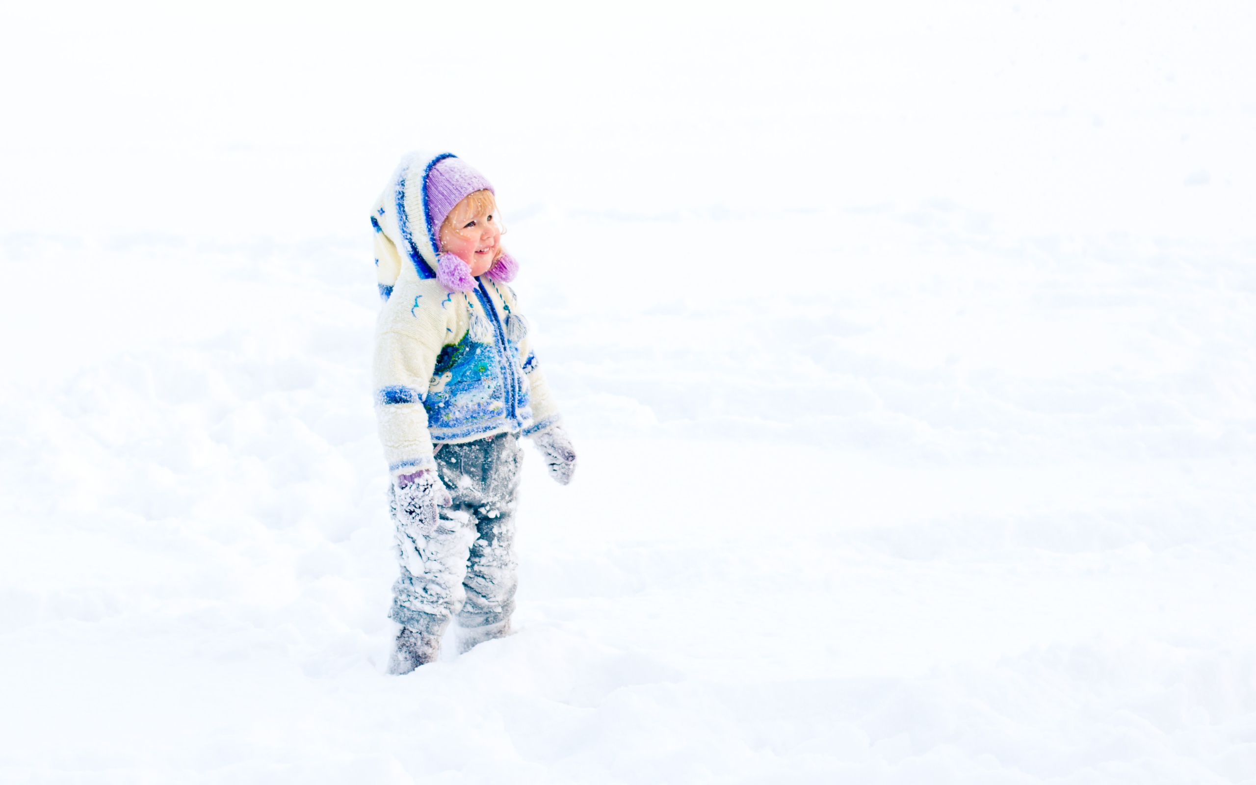 Маленькая веселая девочка гуляет по снегу