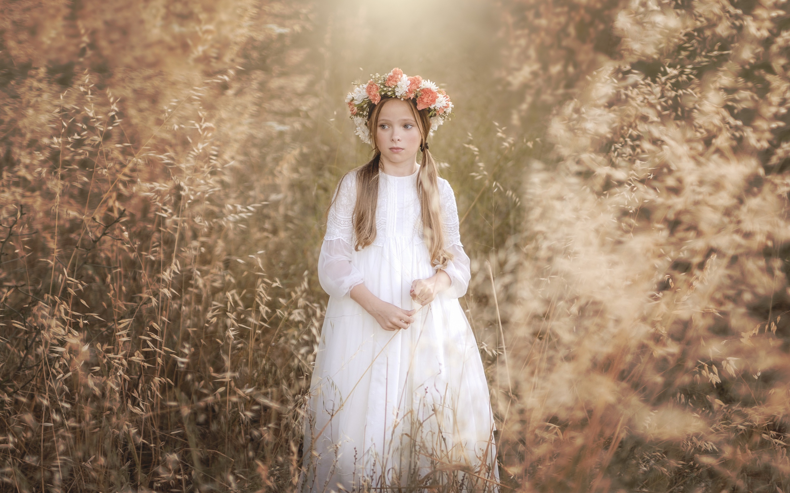 Маленькая девочка в белом платье с венком на голове 