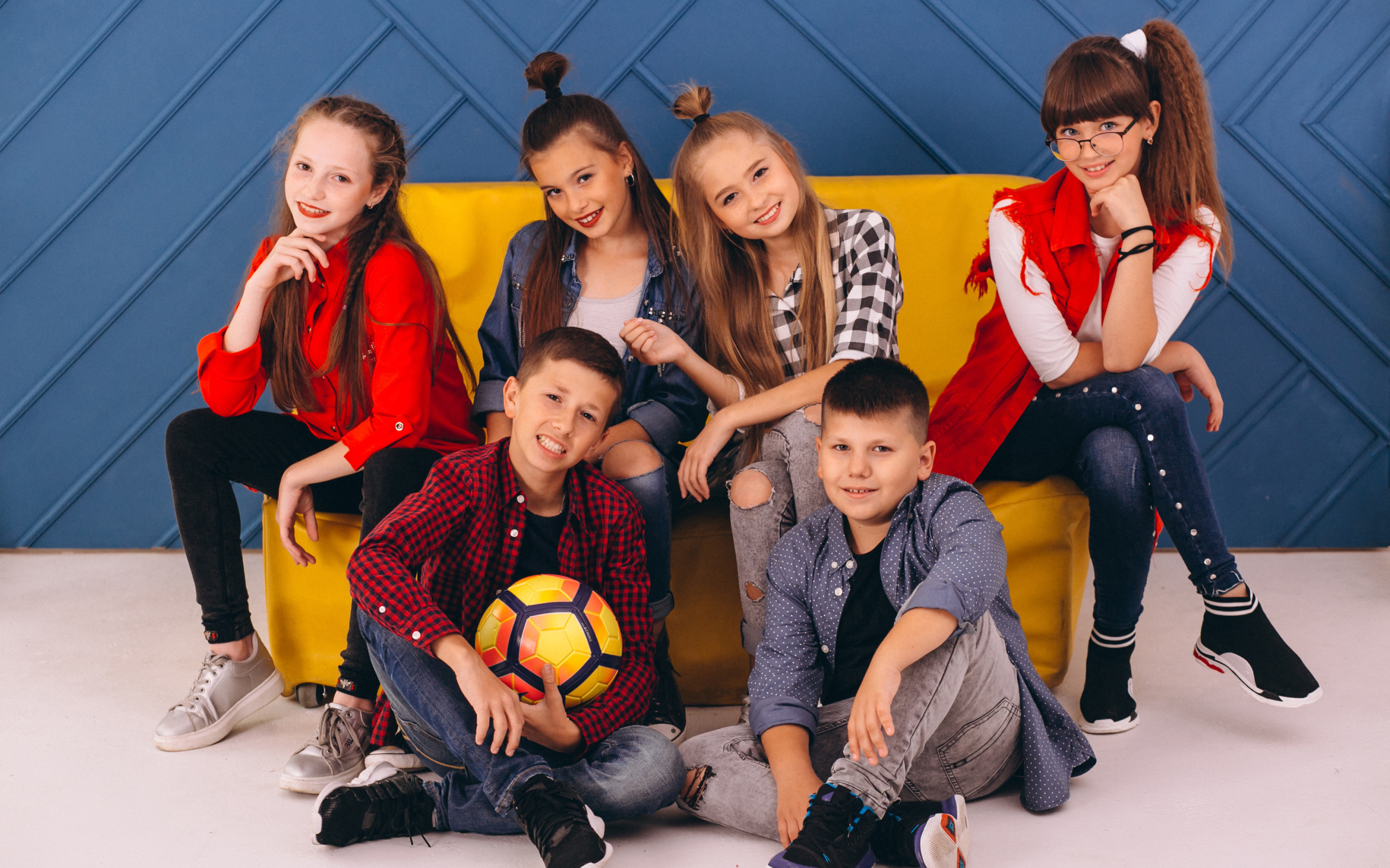 Много модных школьников сидят на диване