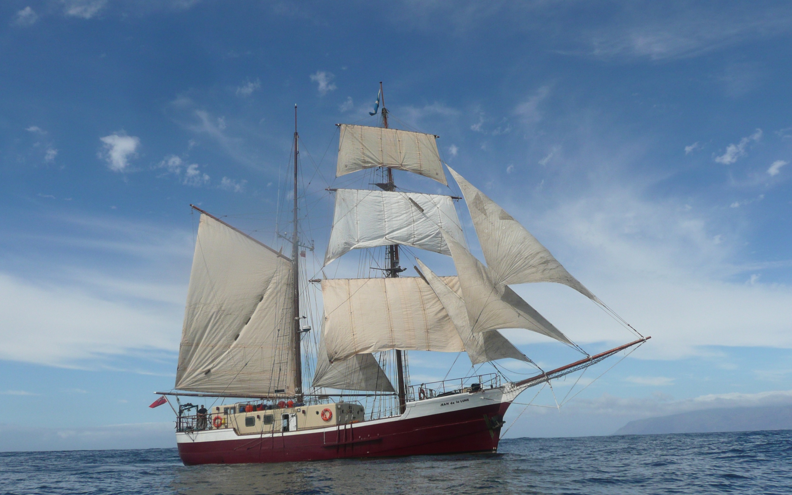 Больше судно с белыми парусами в море 