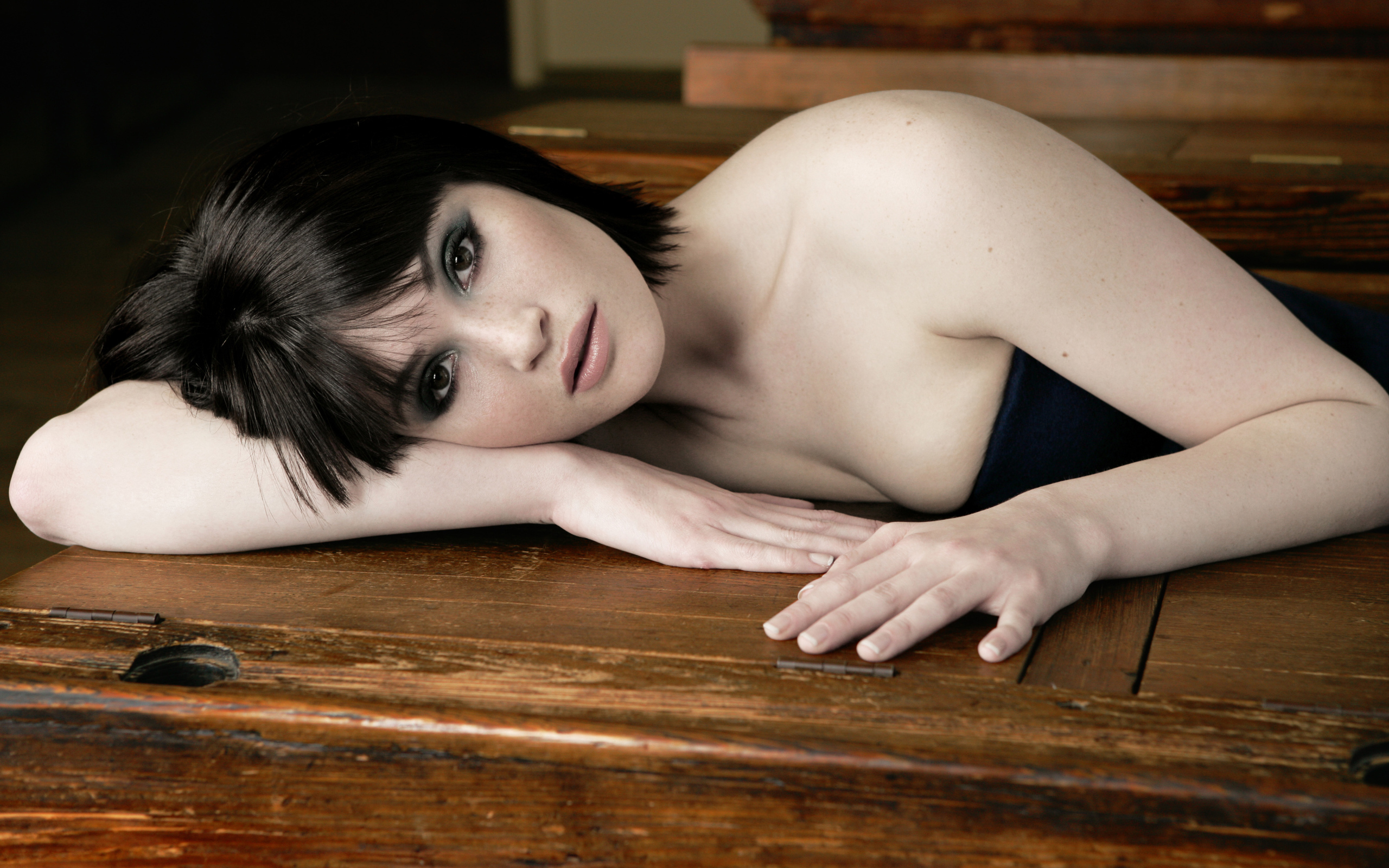 Актриса Джемма Артертон лежит на деревянном столе