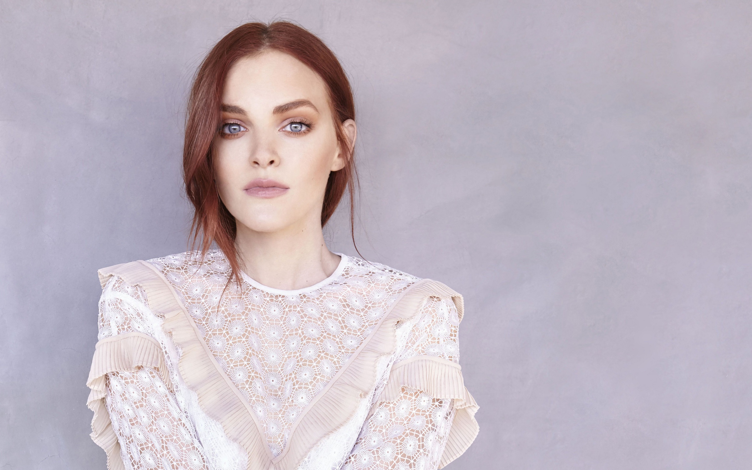Актриса Мадлен Брюэр в белом платье на фоне стены