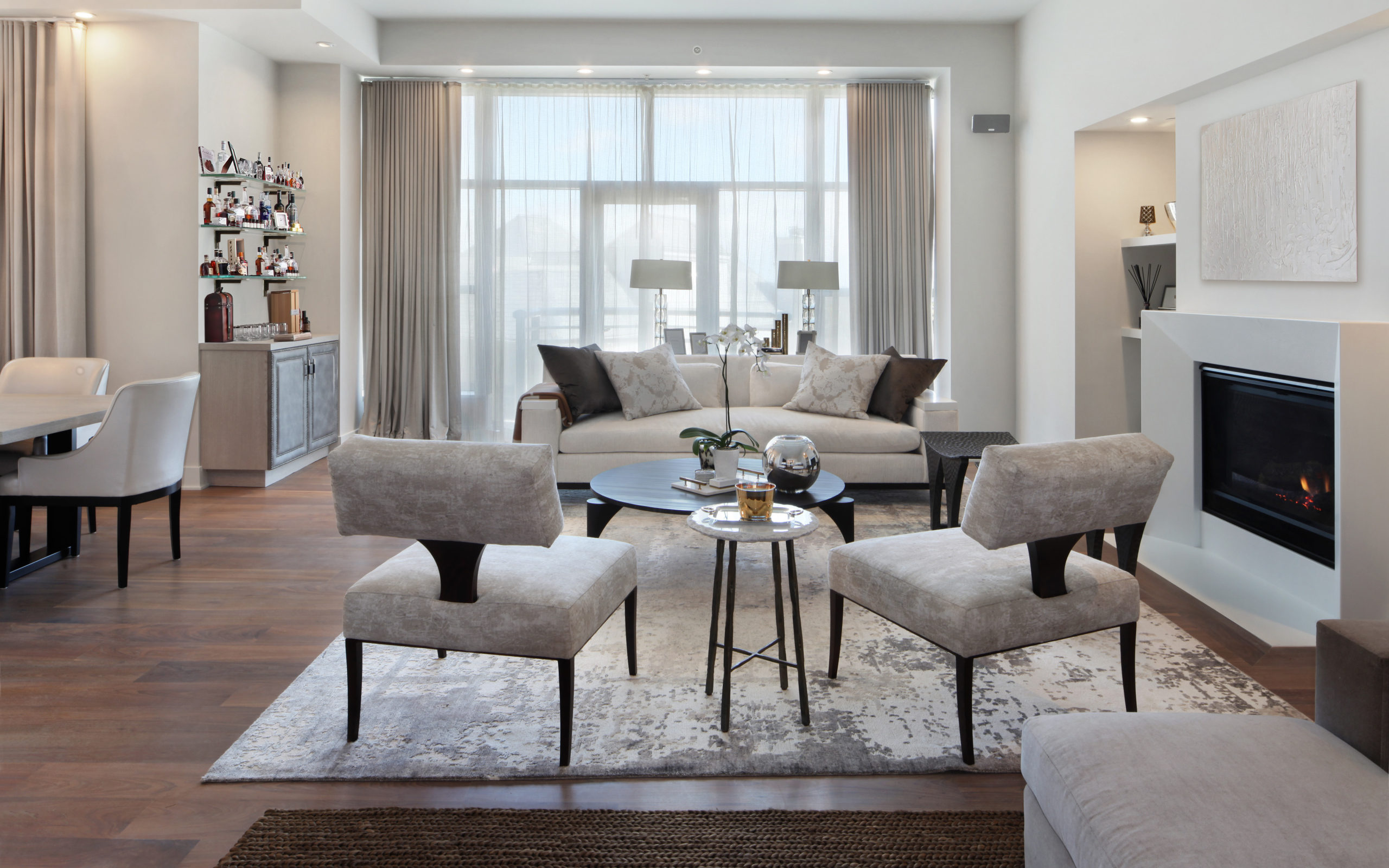 Красивая светлая гостиная с камином и большим окном