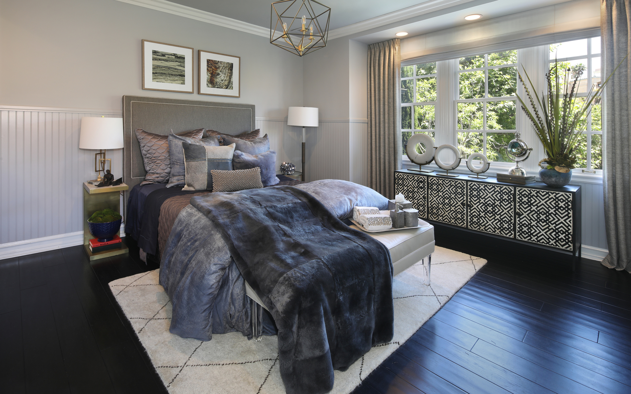 Большая кровать с мягким серым покрывалом в спальне 