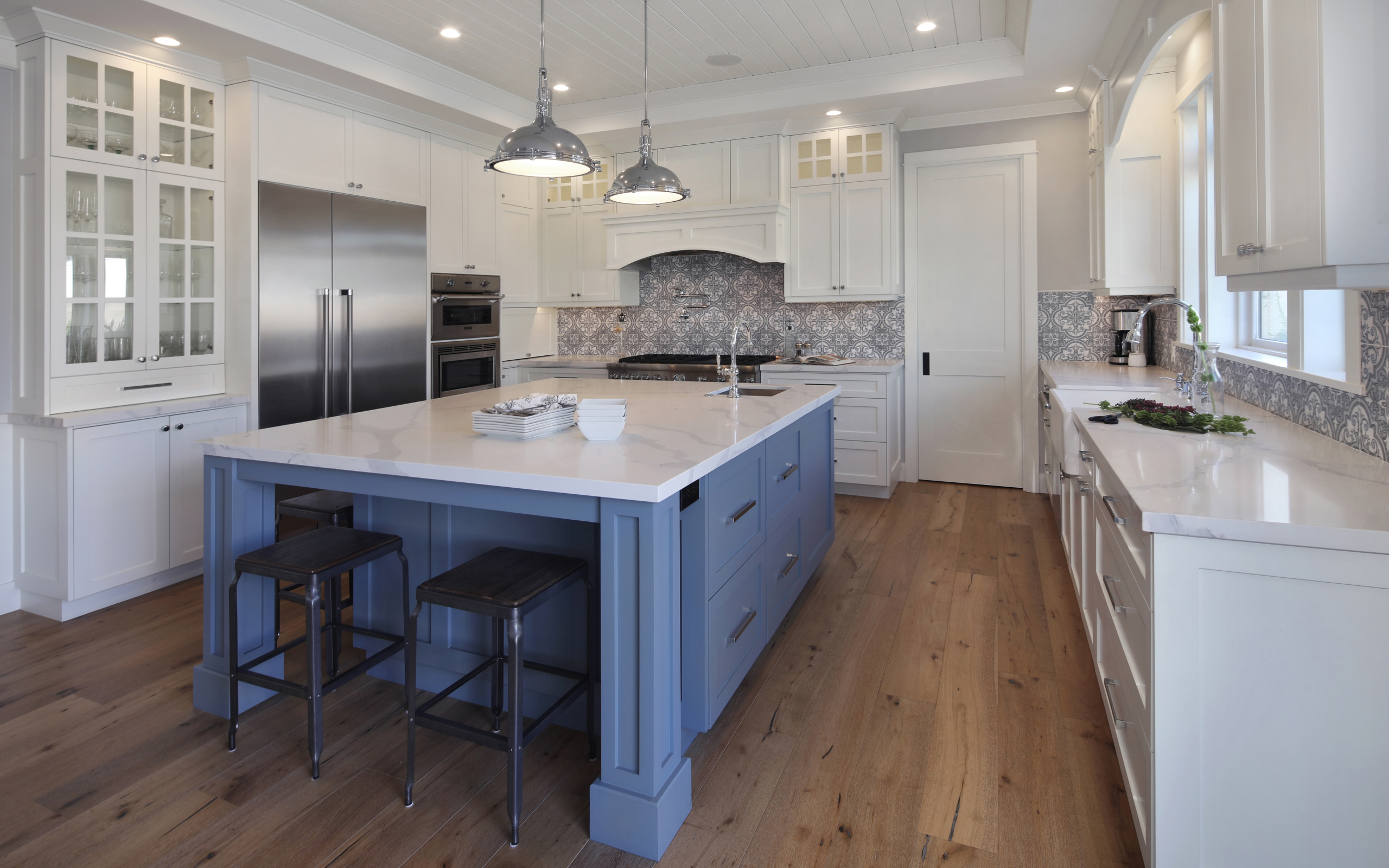 Большой серый стол в просторной белой кухне 