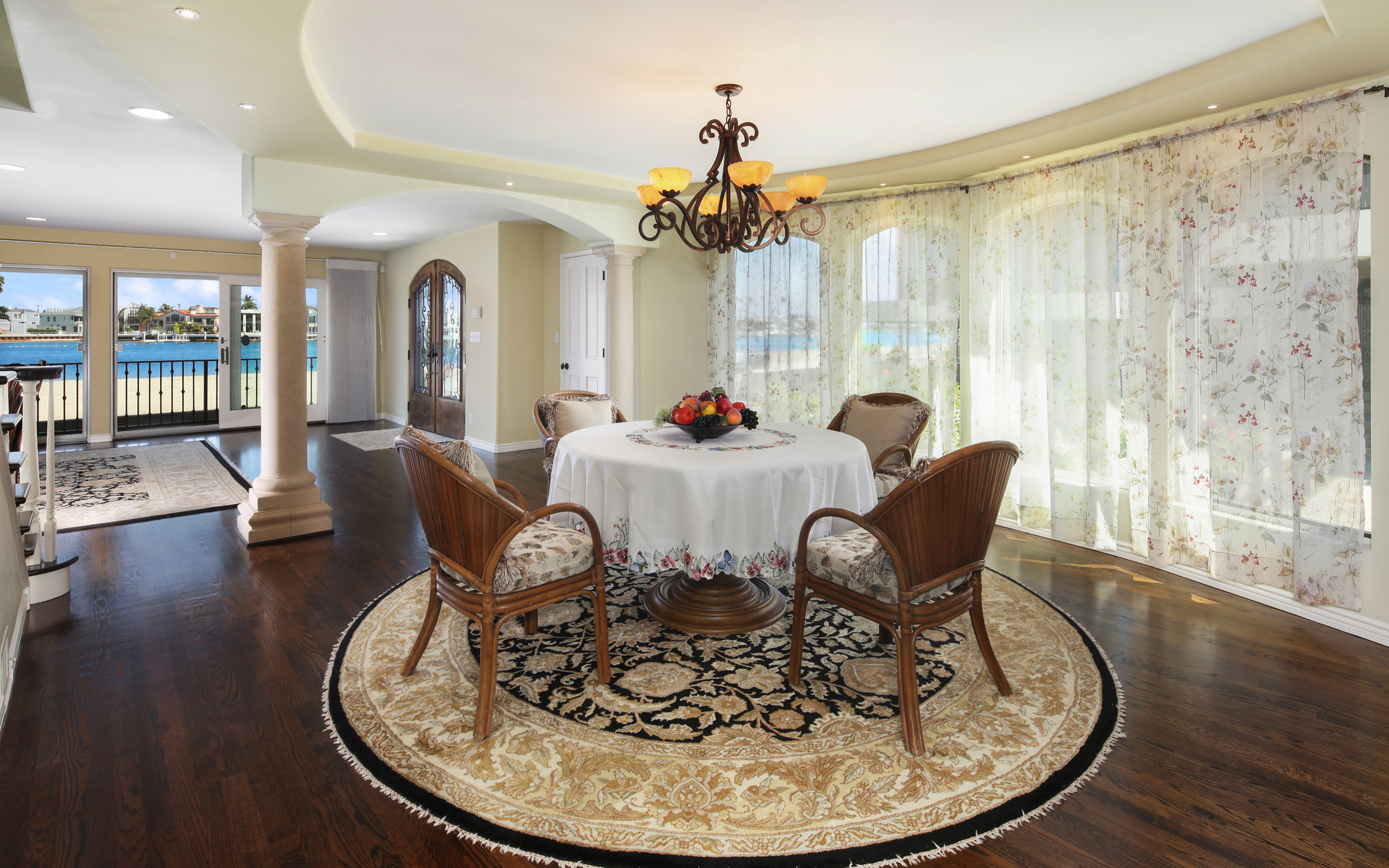 Большая гостиная комната с большими окнами и столом 