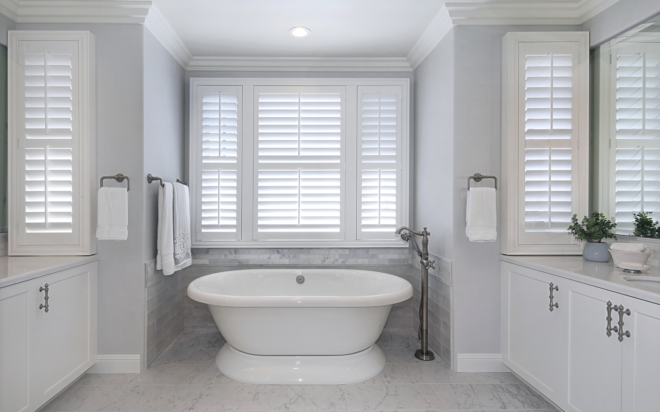 Большая белая ванна в комнате с окнами