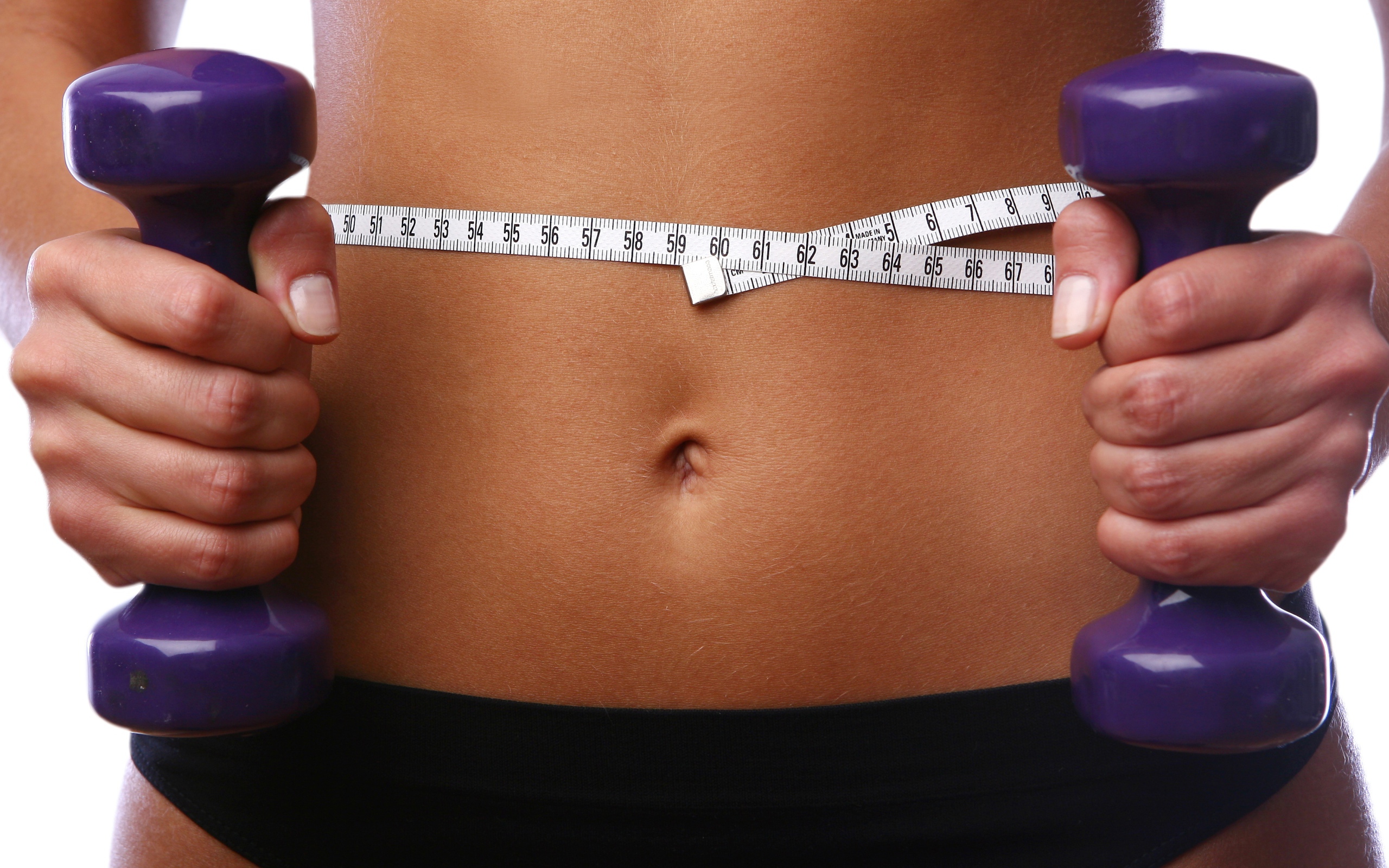 Стройная спортивная девушка с гантелями в руках 