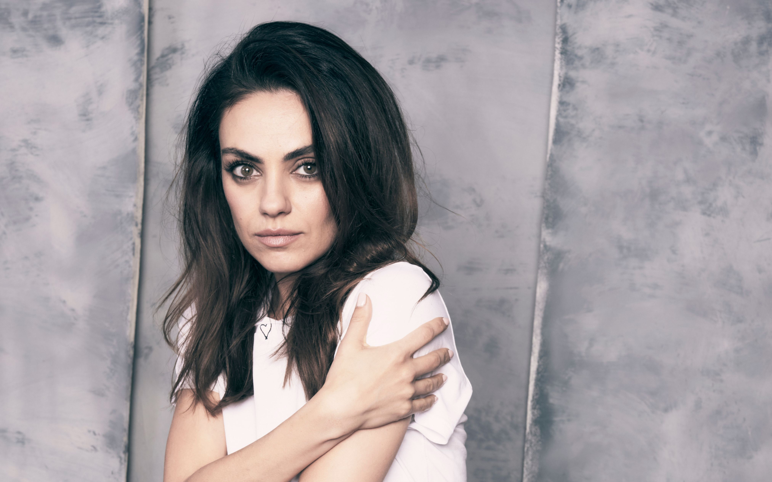 Нежная девушка, актриса Мила Кунис на сером фоне