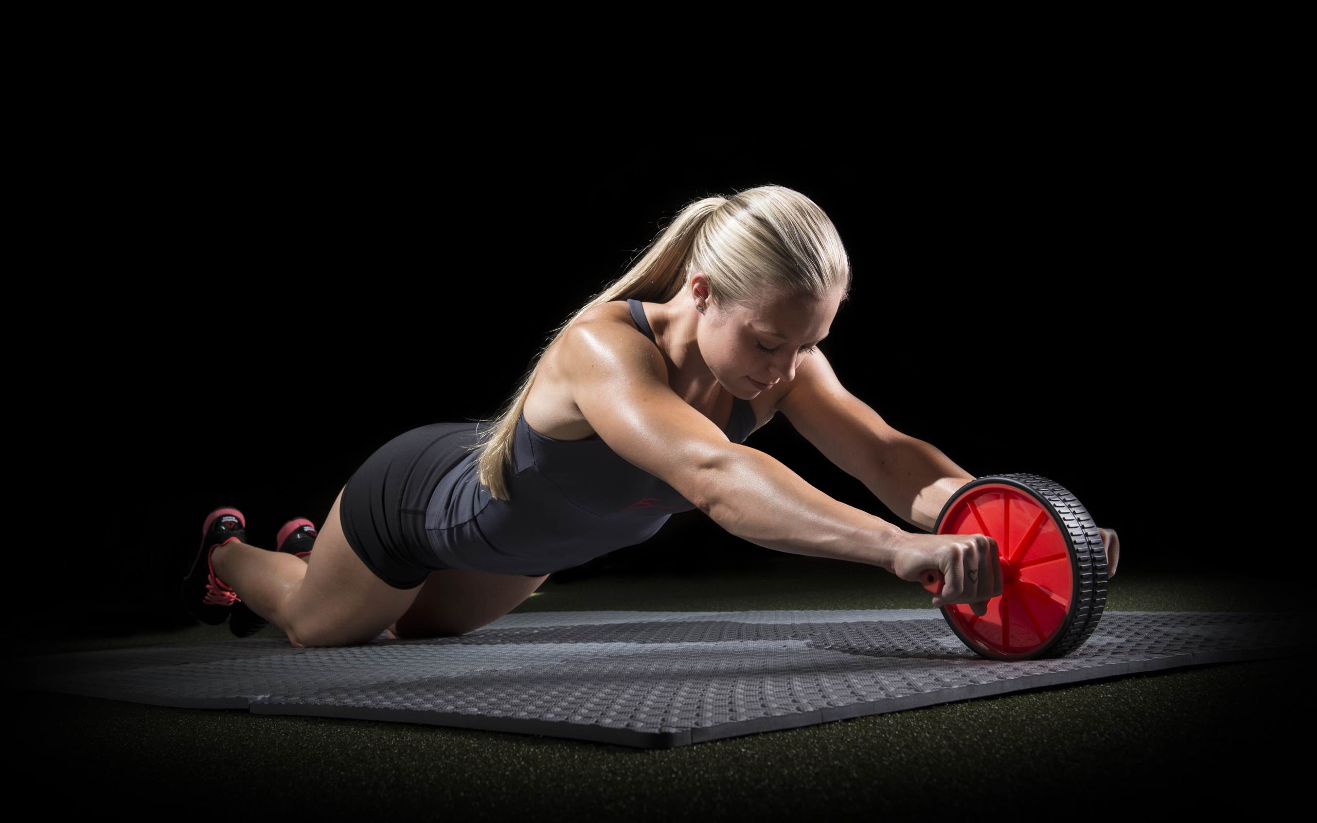 Девушка занимается фитнесом с колесом