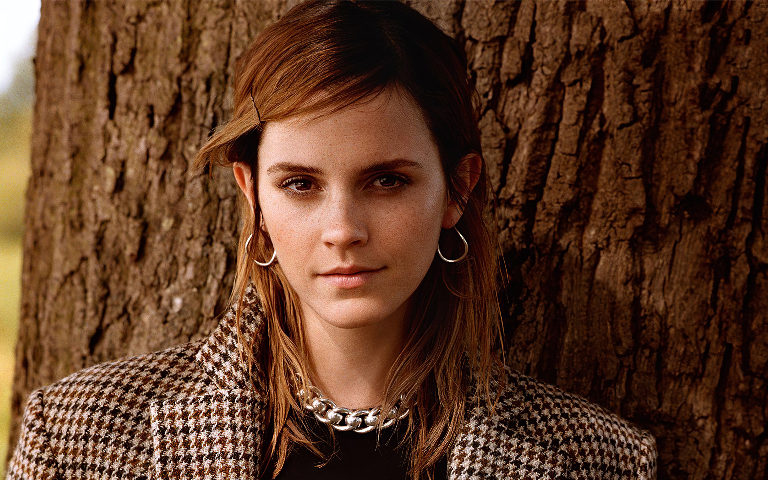 Молодая кареглазая девушка, актриса Эмма Уотсон у дерева