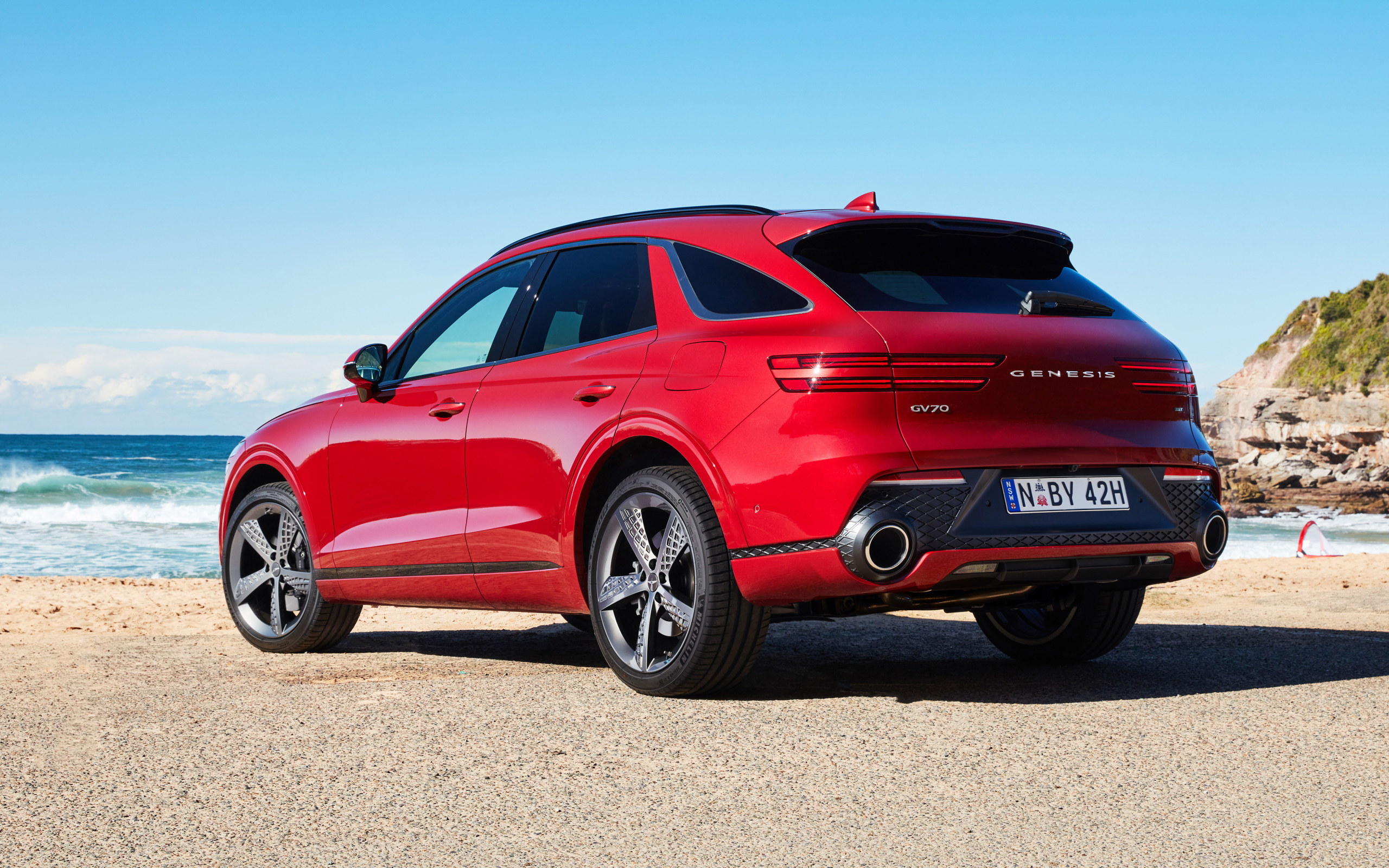 Красный автомобиль Genesis GV70 2.5T AWD 2021 года вид сзади 