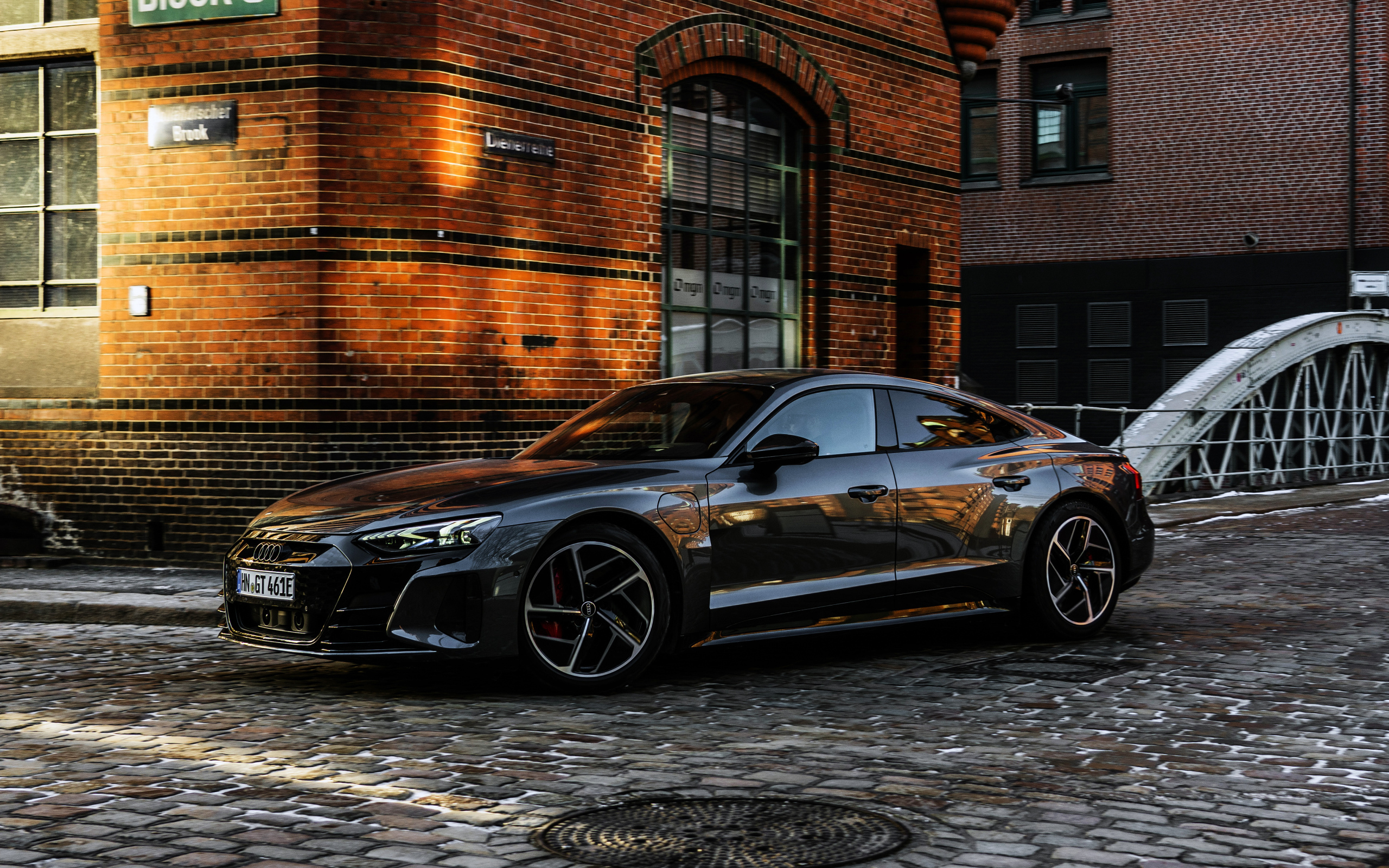 Черный автомобиль Audi RS E-Tron GT 2021 года у здания