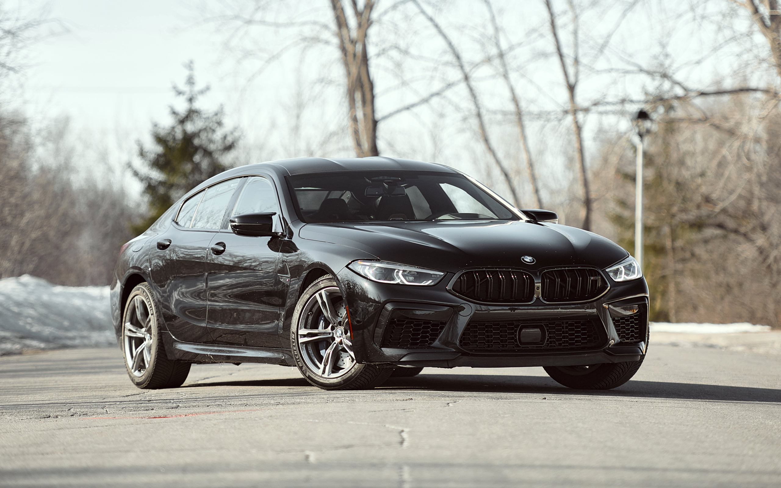 Черный автомобиль BMW M8 в лучах солнца