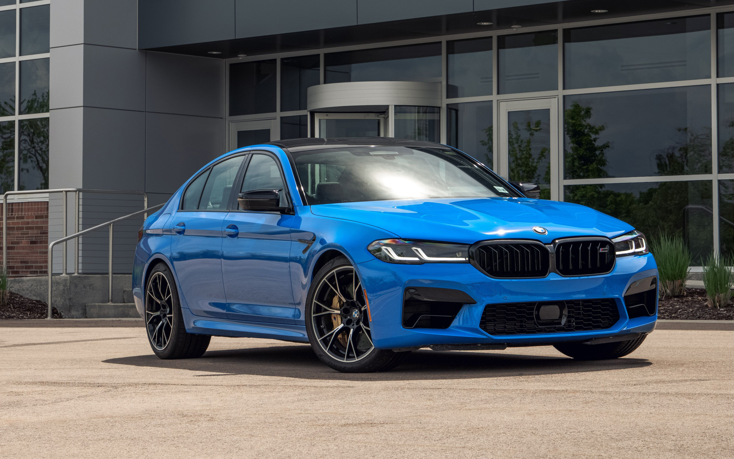 Голубой автомобиль BMW M5, 2021 года у здания