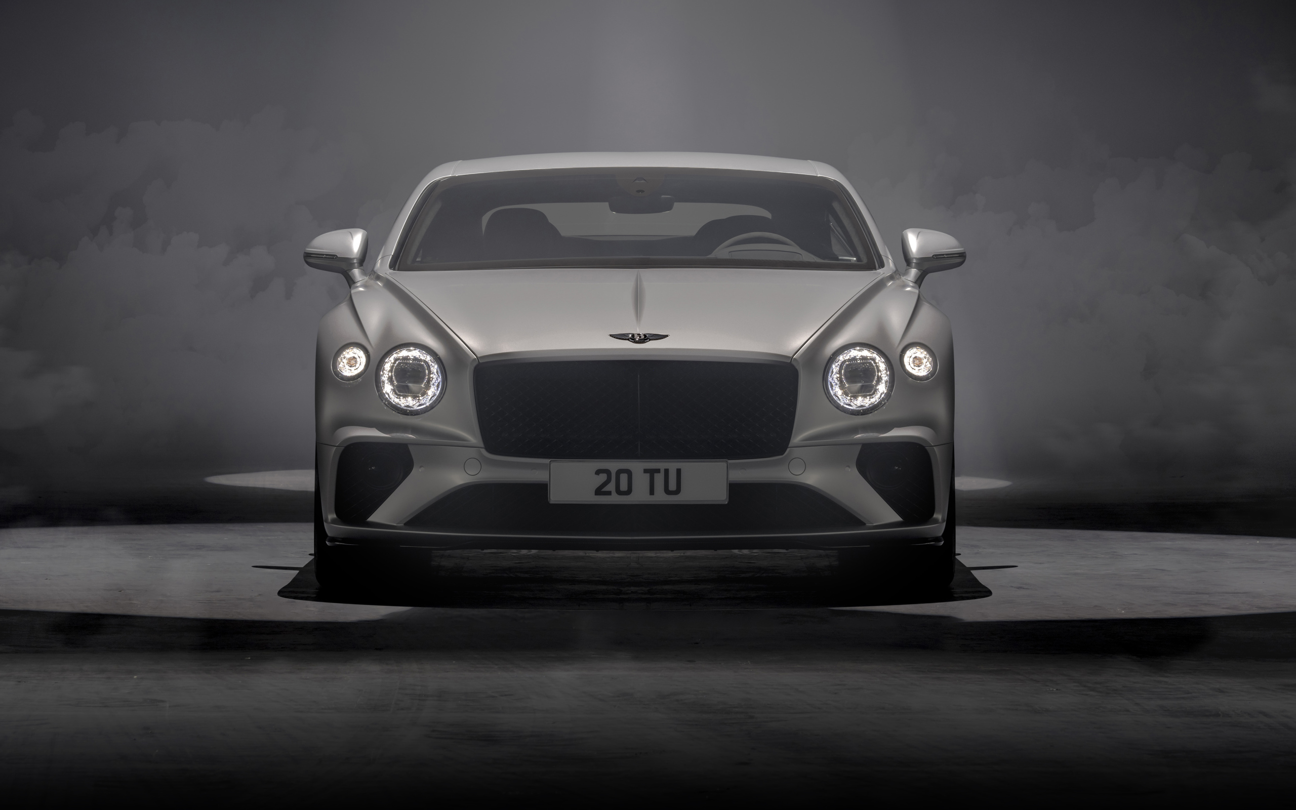 Серебристый автомобиль Bentley Continental GT Speed 2021 года на сером фоне